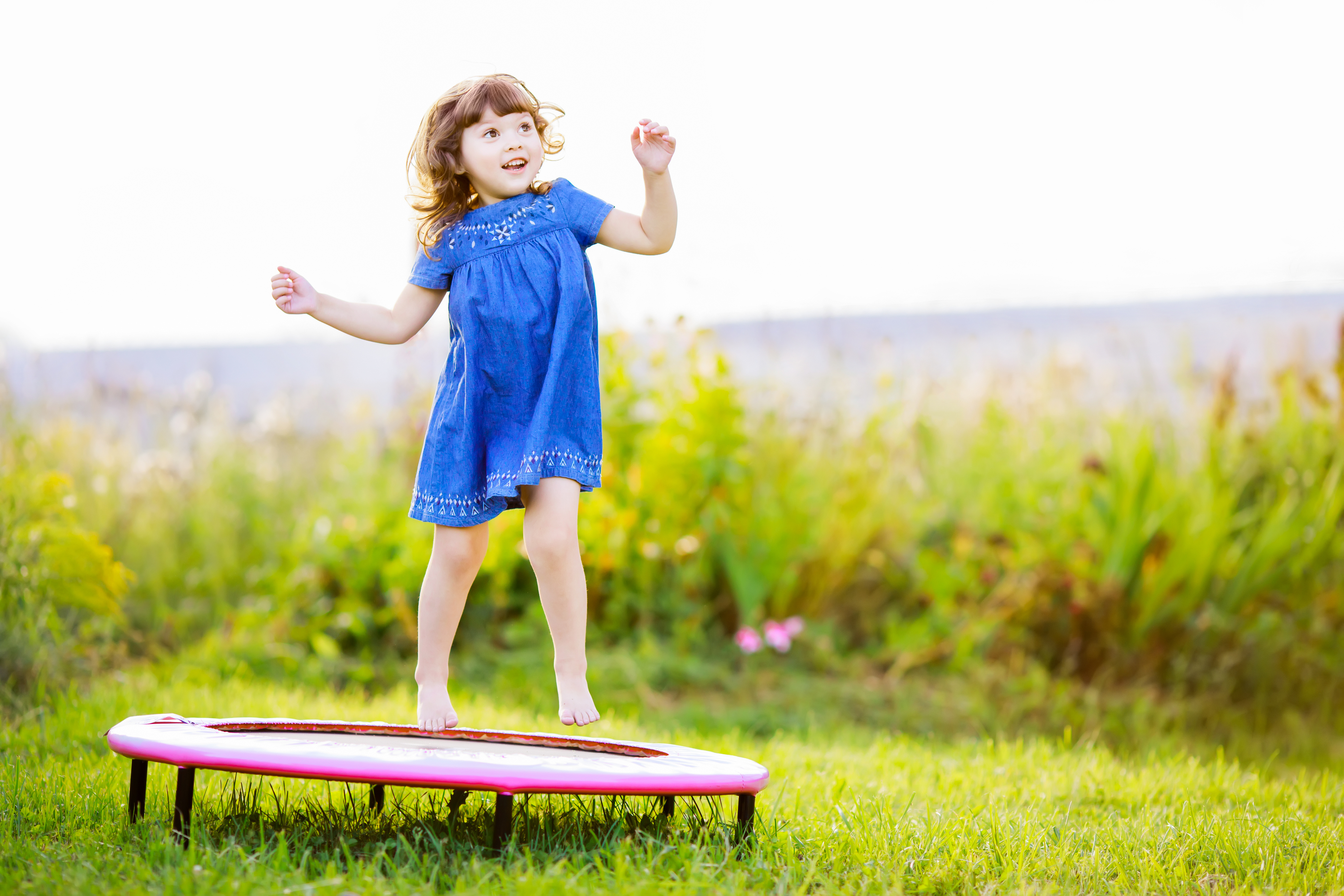 Ein Mädchen springt auf einem Outdoor-Trampolin. Symbolbild