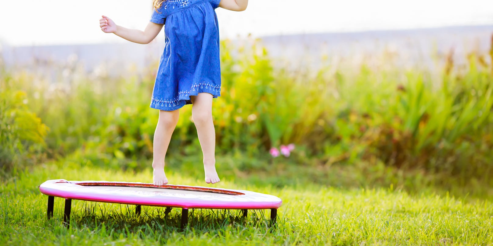 Ein Mädchen springt auf einem Outdoor-Trampolin. Symbolbild