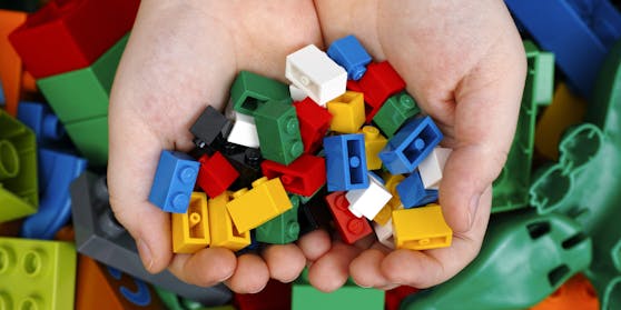 Spielsteine eines bekannten Herstellers in den Händen von Kindern. (Symbolbild)