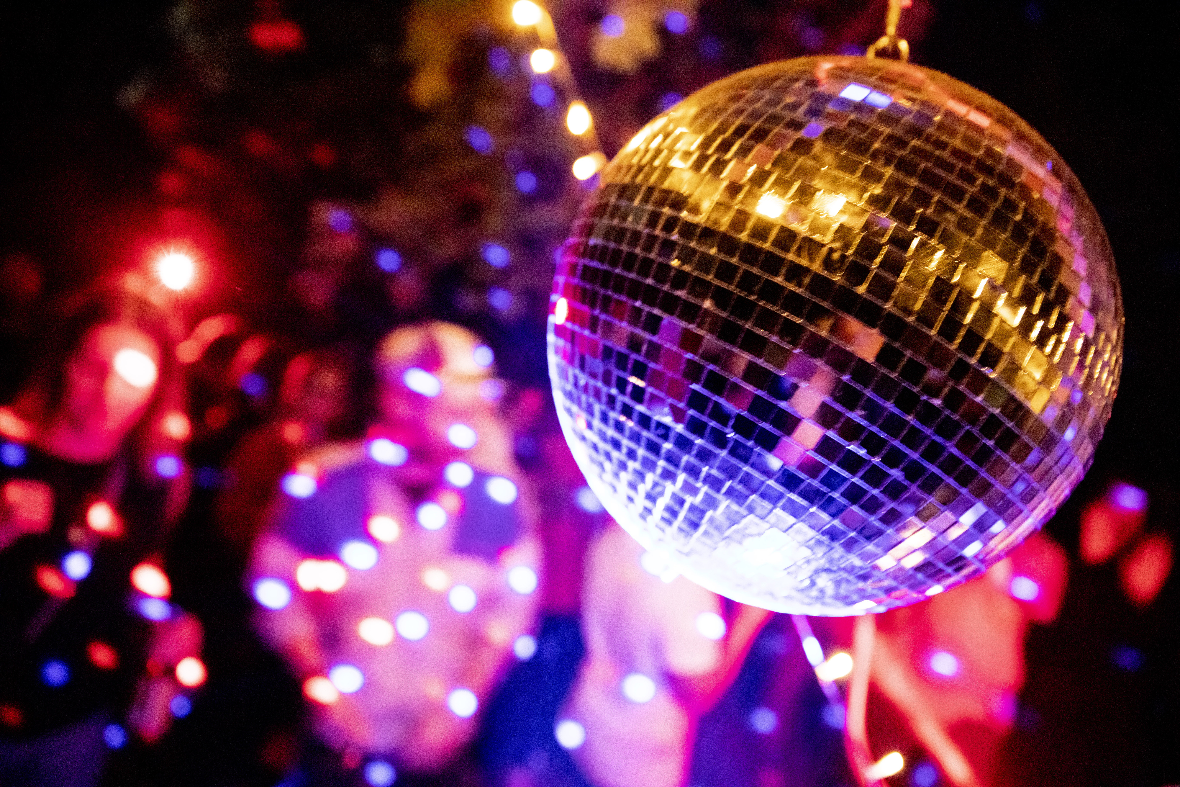 Symbolbild: Menschen feiern eine Party samt Discokugel