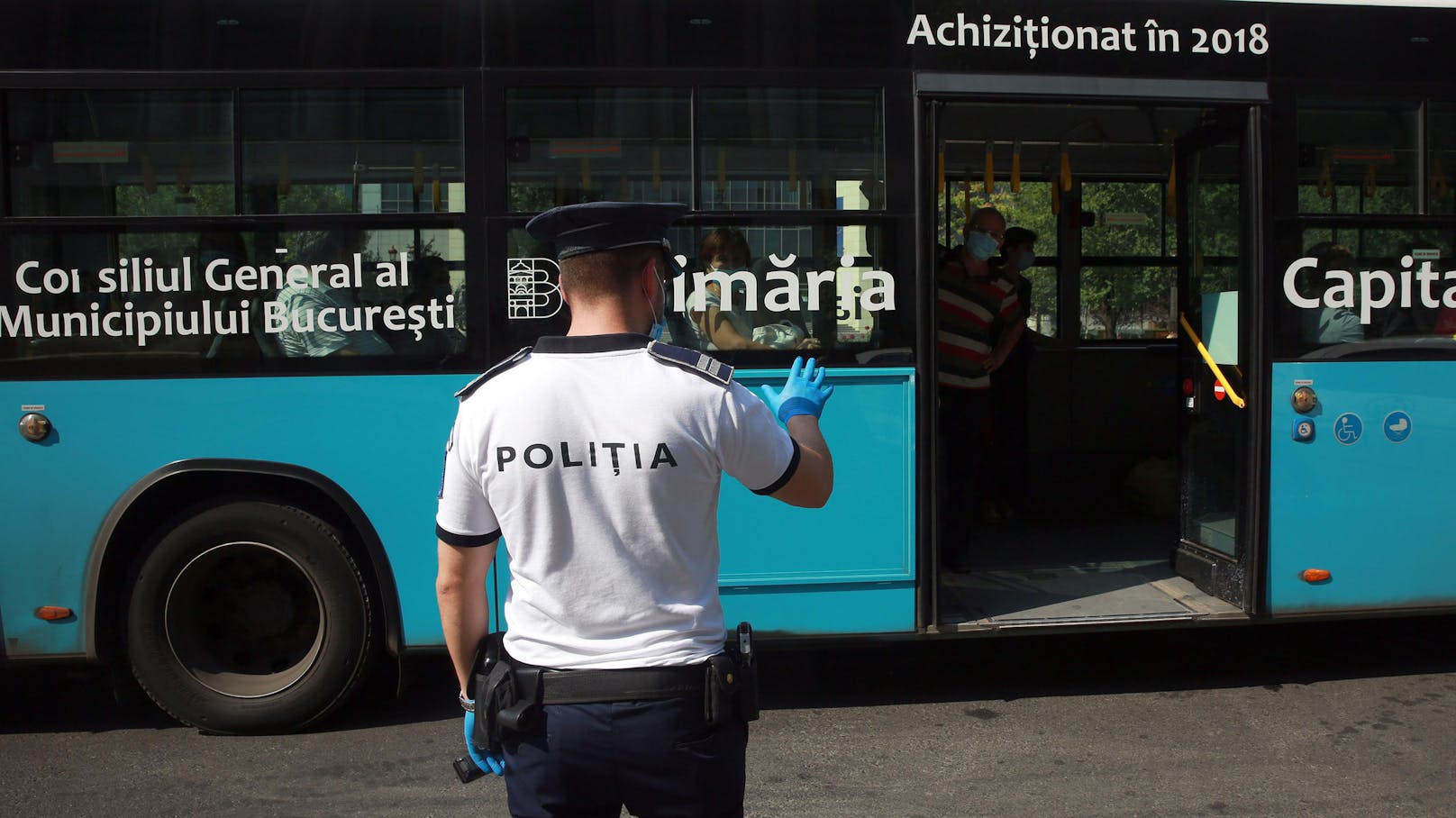 Ein rumänischer Polizist hält in Bukarest, Rumänien, einen Bus an, um die Verwendung von Masken der Passagiere zu überprüfen,