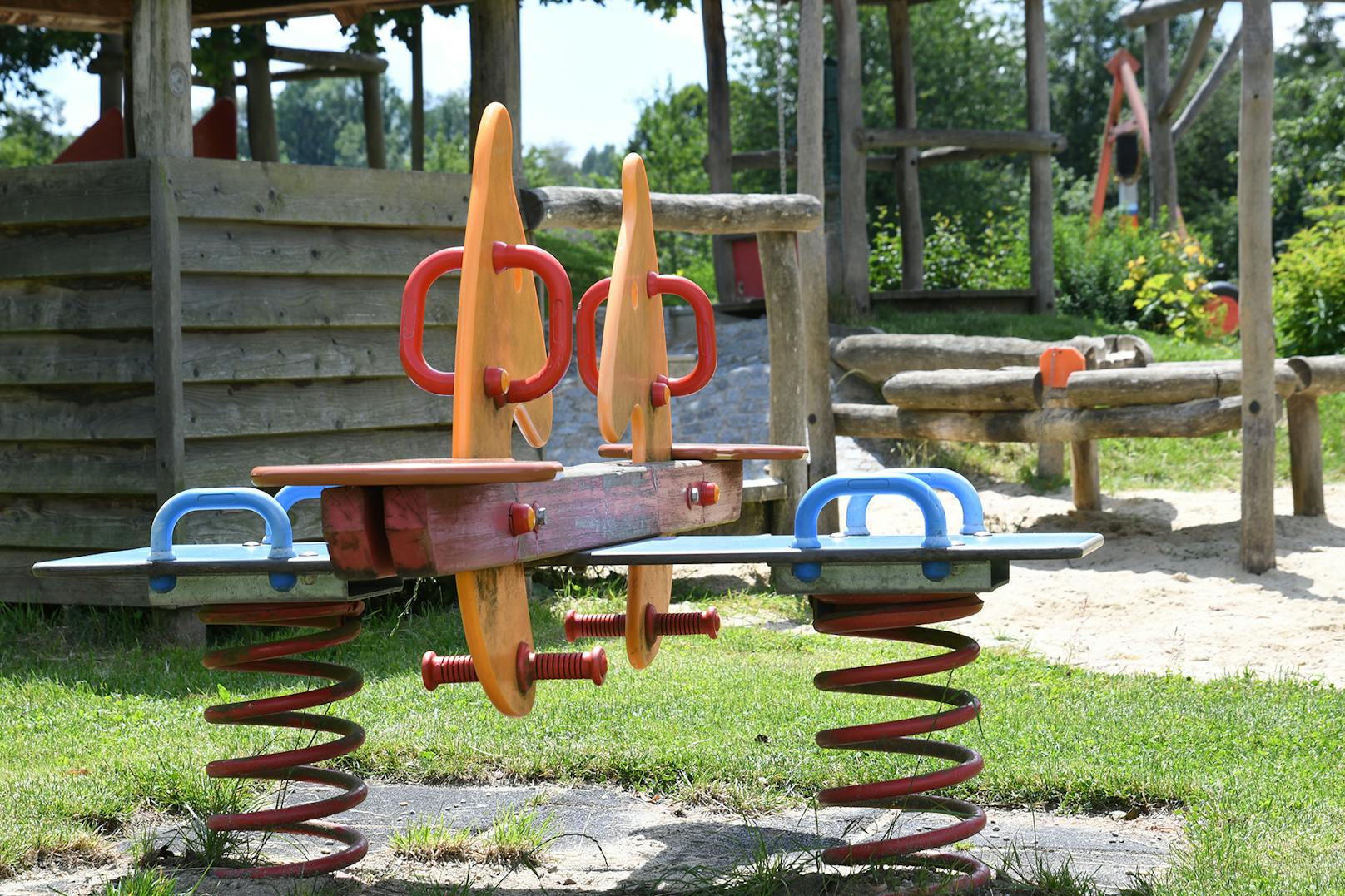 Spielgeräte für Kinder mit Schaukel und Rutsche auf einem Spielplatz