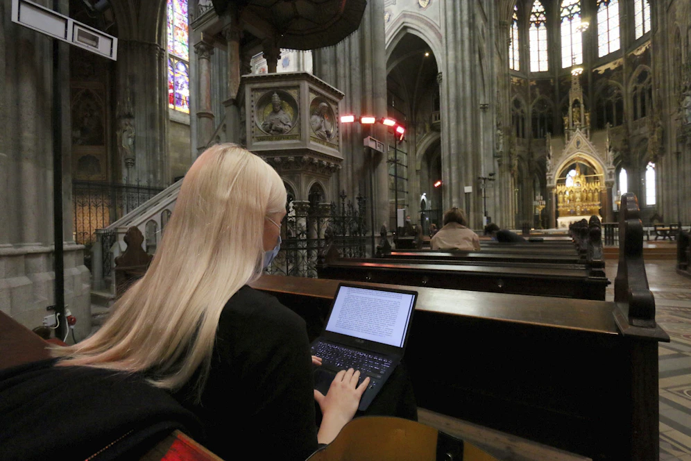 Studenten in der Wiener Votivkirche verfolgen mit Maske und Laptops eine E-Vorlesung.&nbsp;