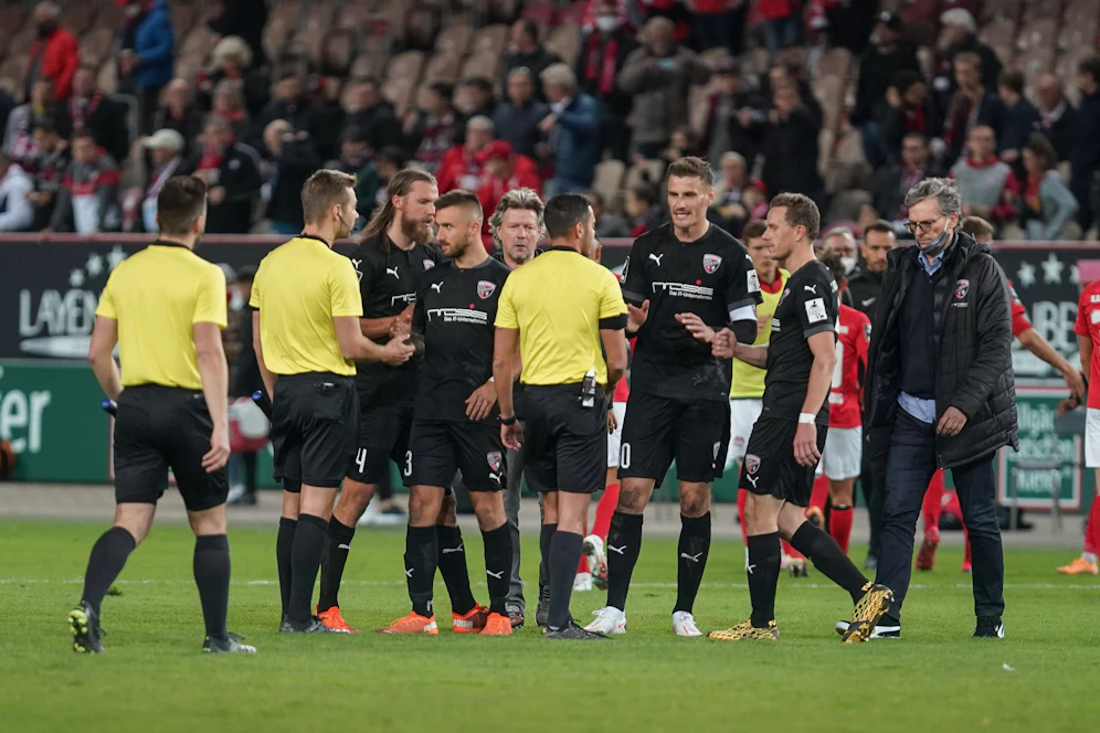 Michael Henke tritt Kaiserslautern-Coach Jeff Saibene in die Beine. 