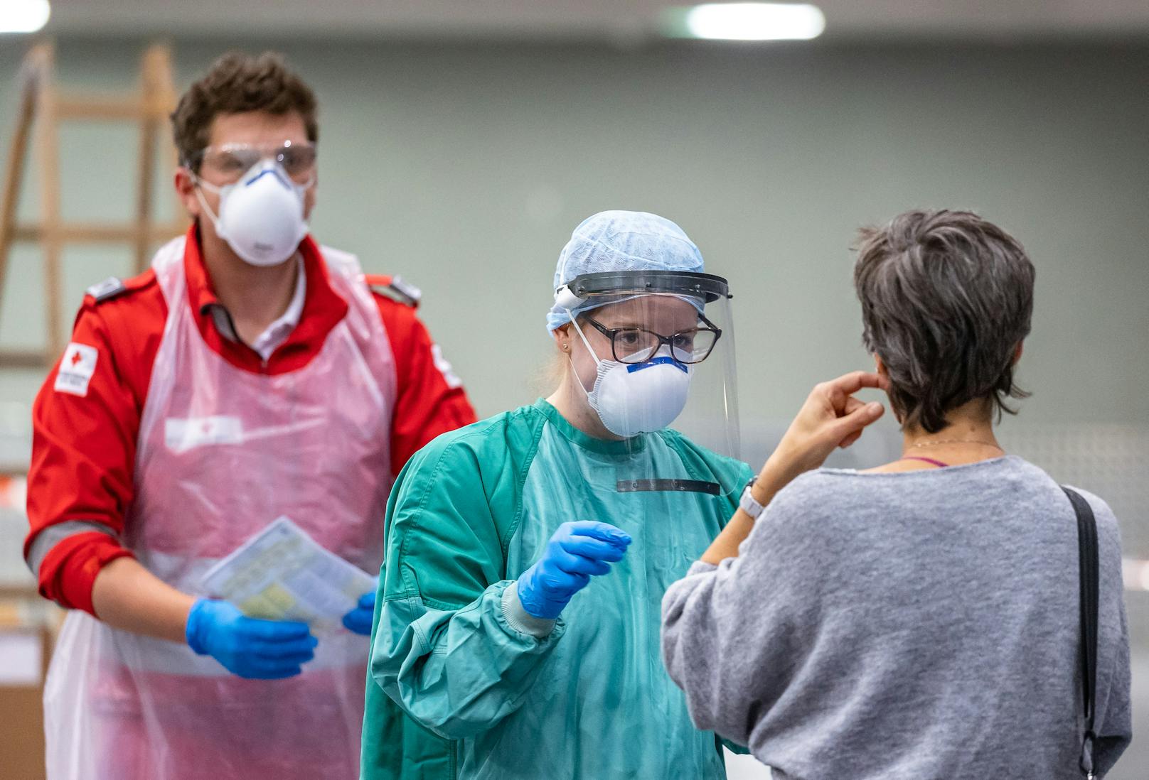 Mitarbeiter des Roten Kreuzes nehmen mit einem Stäbchen einen Abstrich bei Personen mit Erkrankungsverdacht. Symbolbild