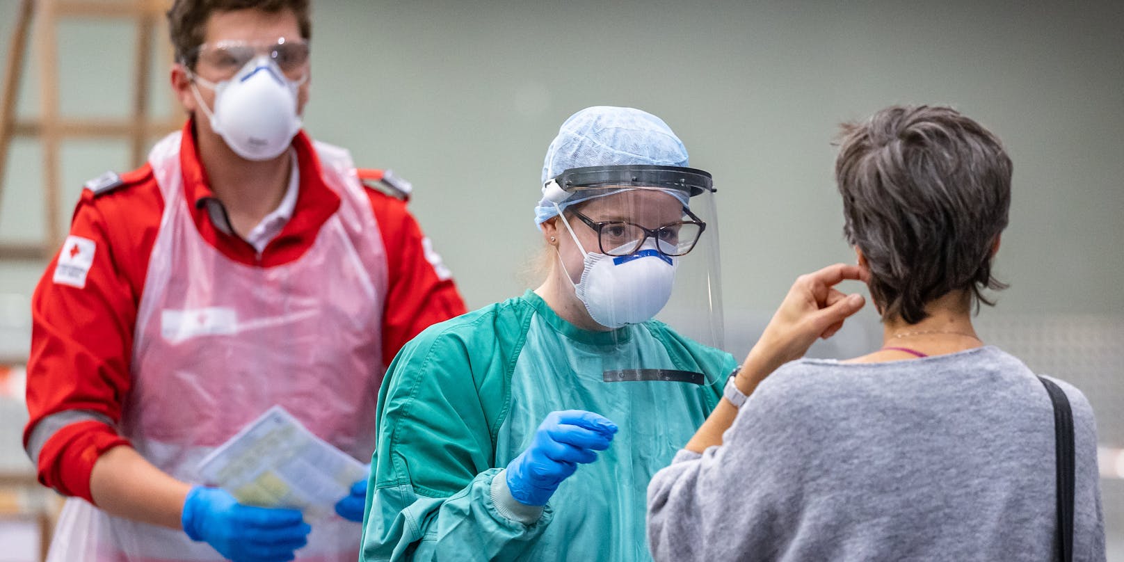 Mitarbeiter des Roten Kreuzes nehmen mit einem Stäbchen einen Abstrich bei Personen mit Erkrankungsverdacht. Symbolbild