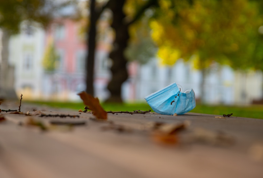 Die Zahlen in OÖ steigen dramatisch (im Foto eine Schutzmaske an der Promenade in Linz). Im benachbarten Bayern wurde über 120.000 Menschen der Lockdown verhängt.