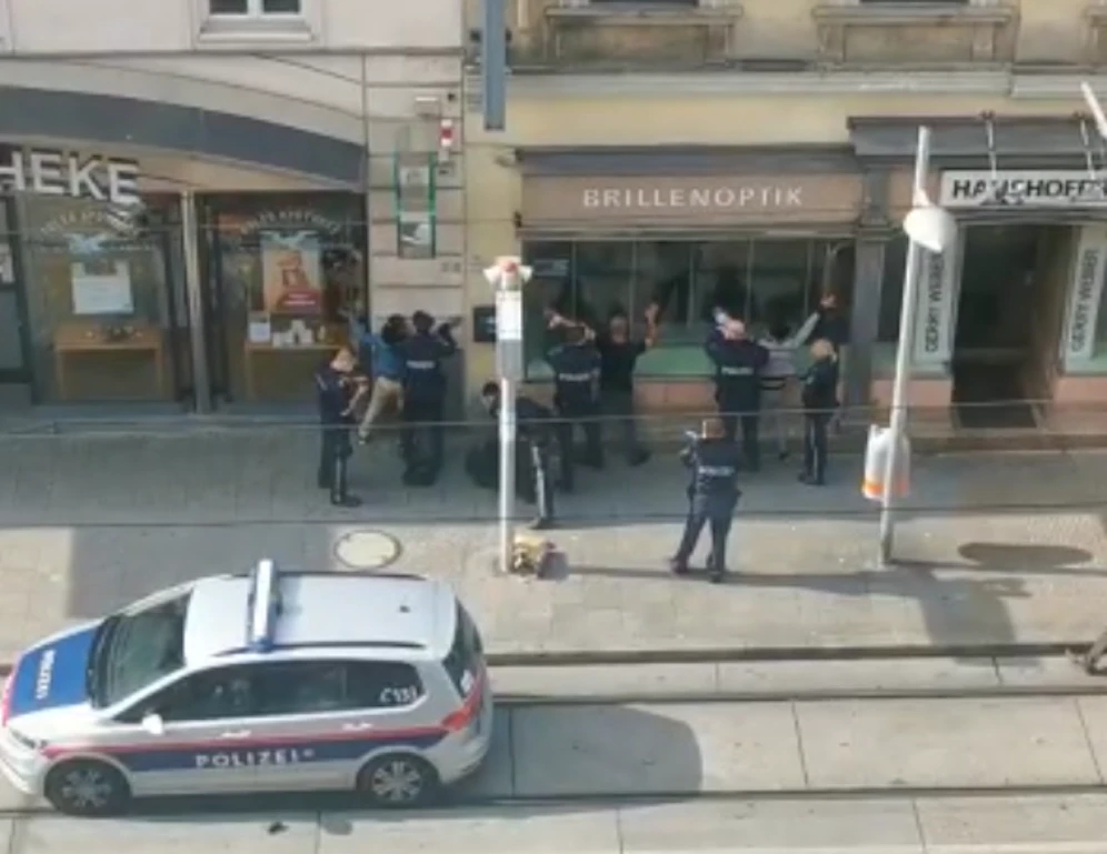 Der Beamte zielte mit seiner Waffe auf die Männer.