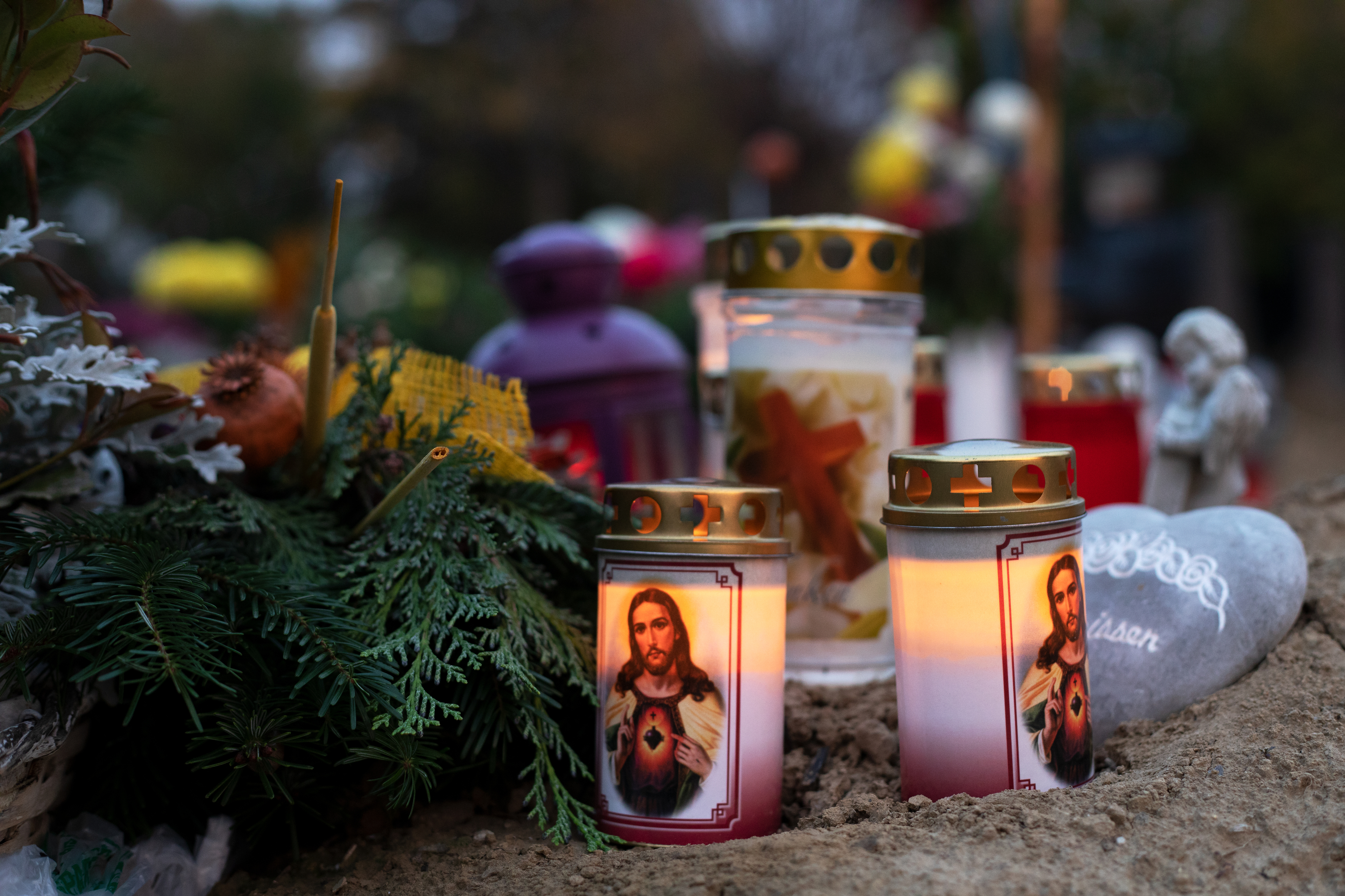 Kerzen brennen in der Abendstimmung an Gräbern am Zentrafriedhof in Wien.