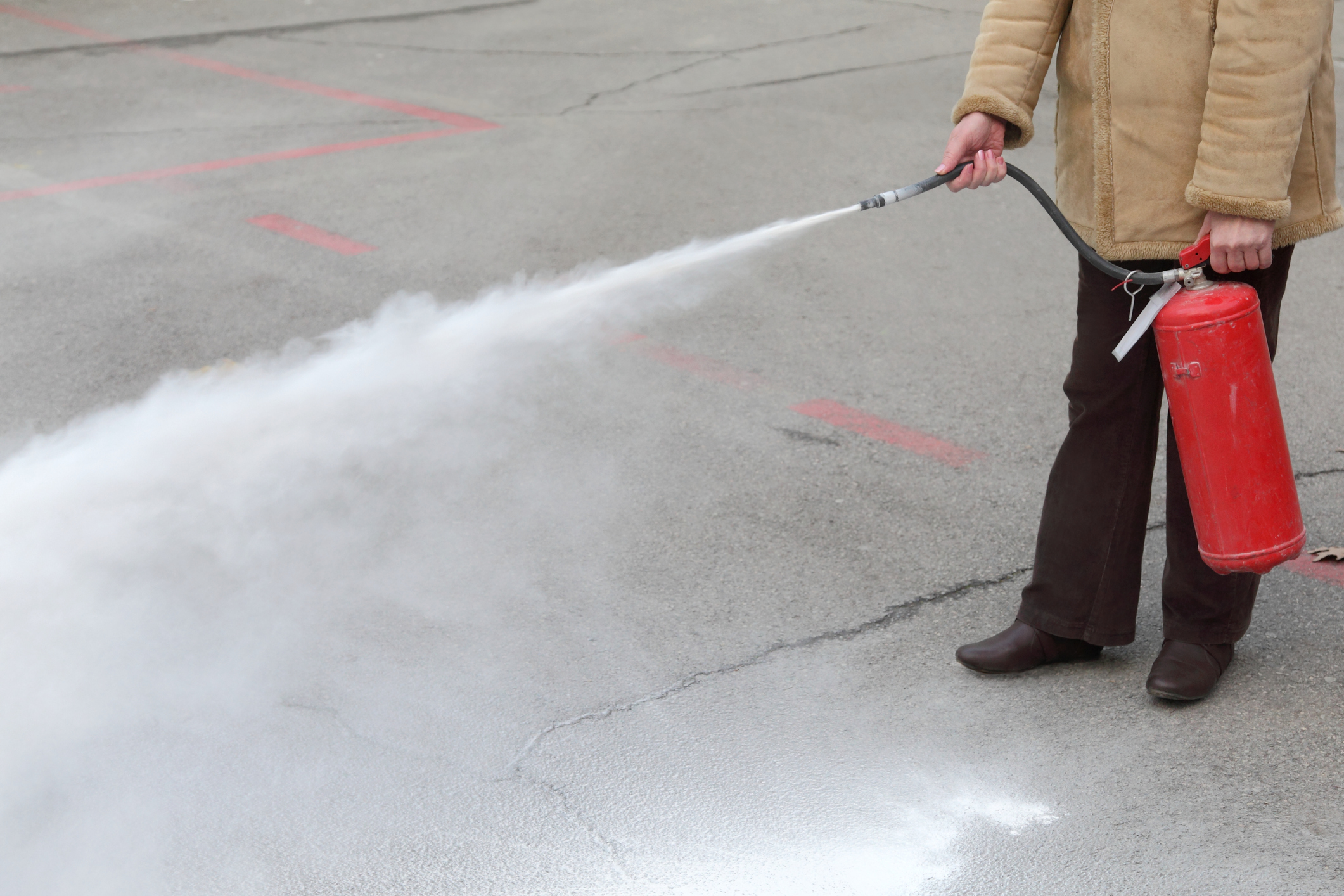 Symbolfoto einer Frau beim Löschen eines Brandes.