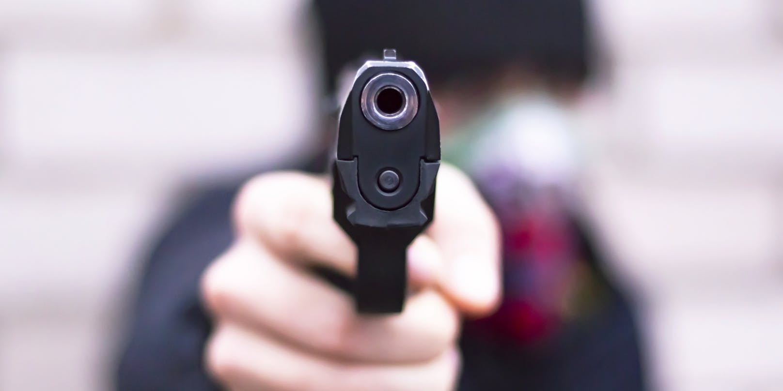 Ein Mann bedroht sein Gegenüber mit einer Pistole. Symbolbild