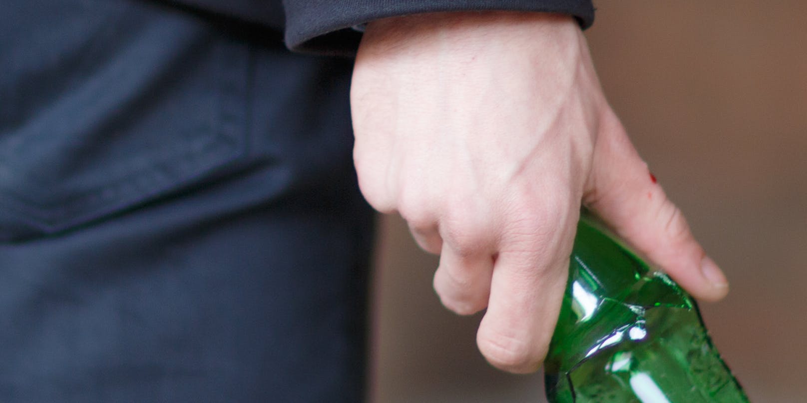 Eine zerbrochene Bierflasche in der Hand eines Mannes. (Symbolbild)