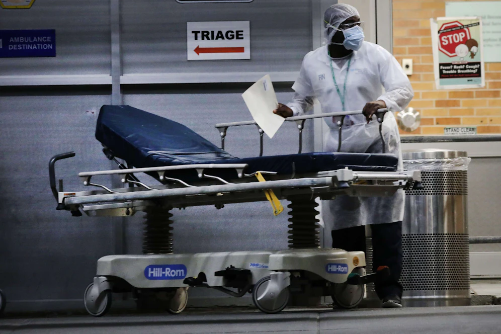 Medizinisches Personal mit einer Krankenliege vor einer Triage-Station in New York