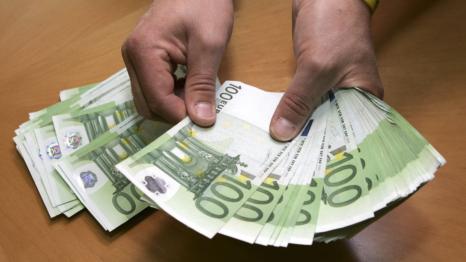 Ein Mann zählt Euro-Banknoten. (Symbolbild)