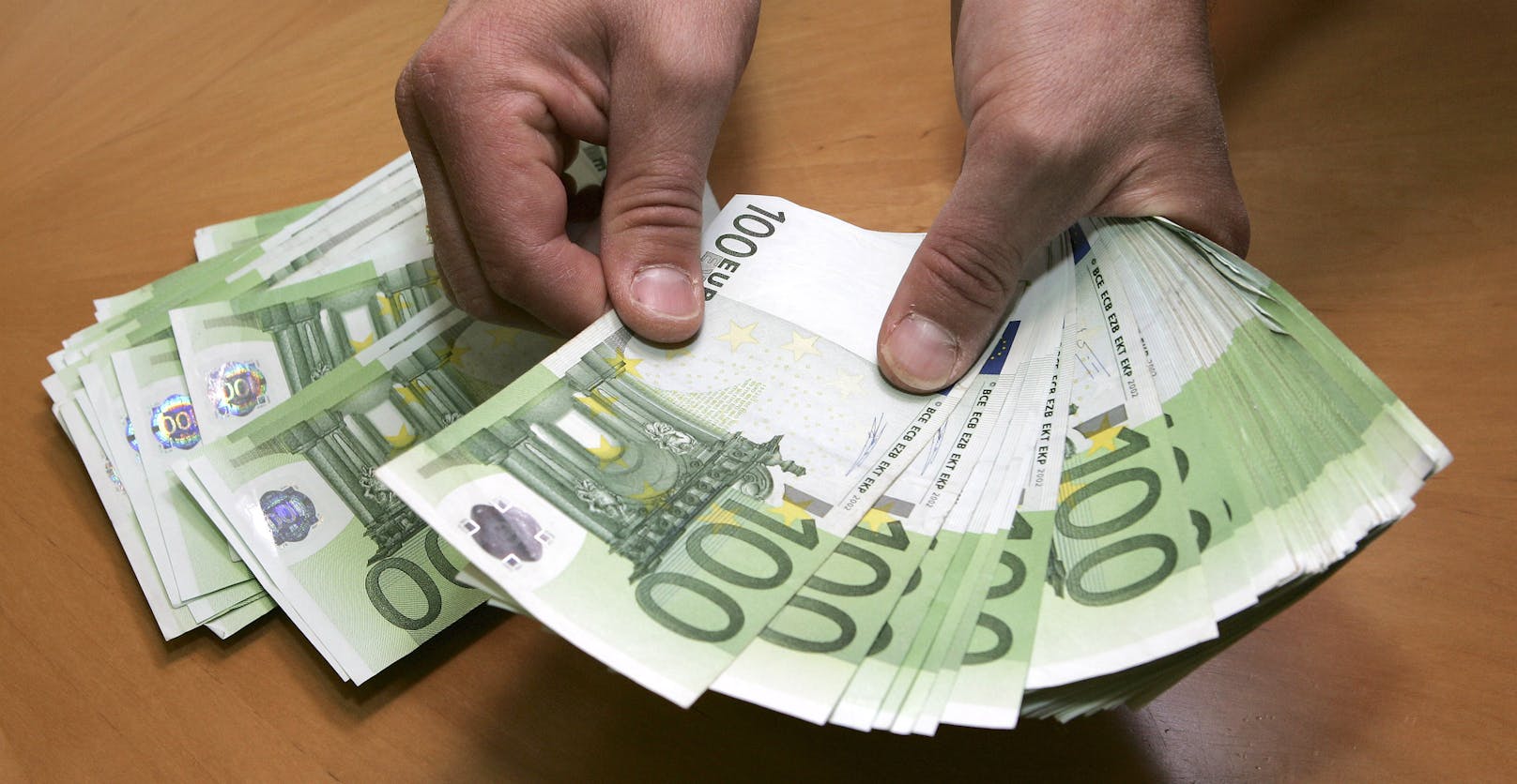 Ein Mann zählt Euro-Banknoten. Symbolbild
