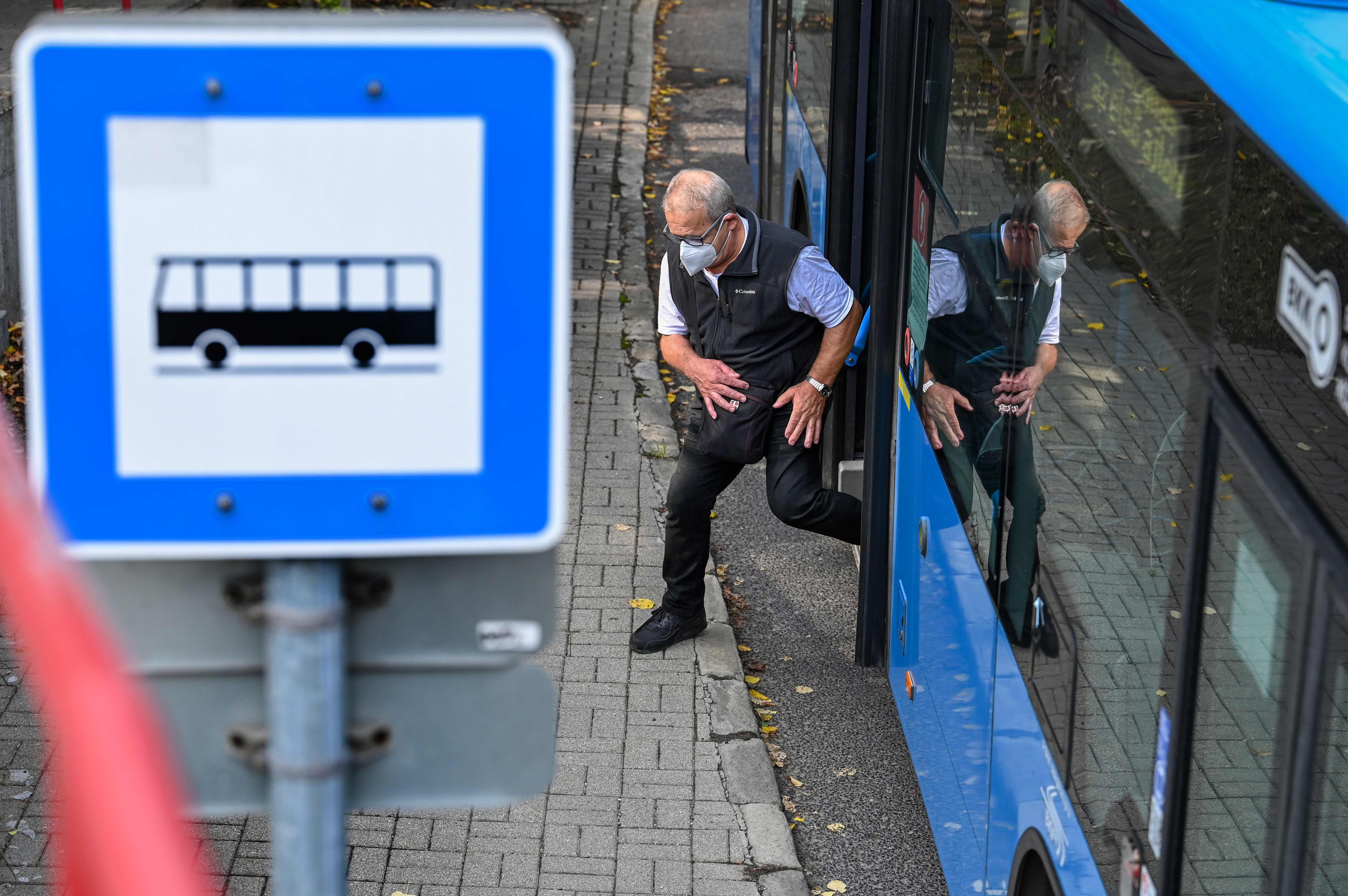 Ein Mann mit Schutzmaske steigt aus einem Bus. Symbolbild