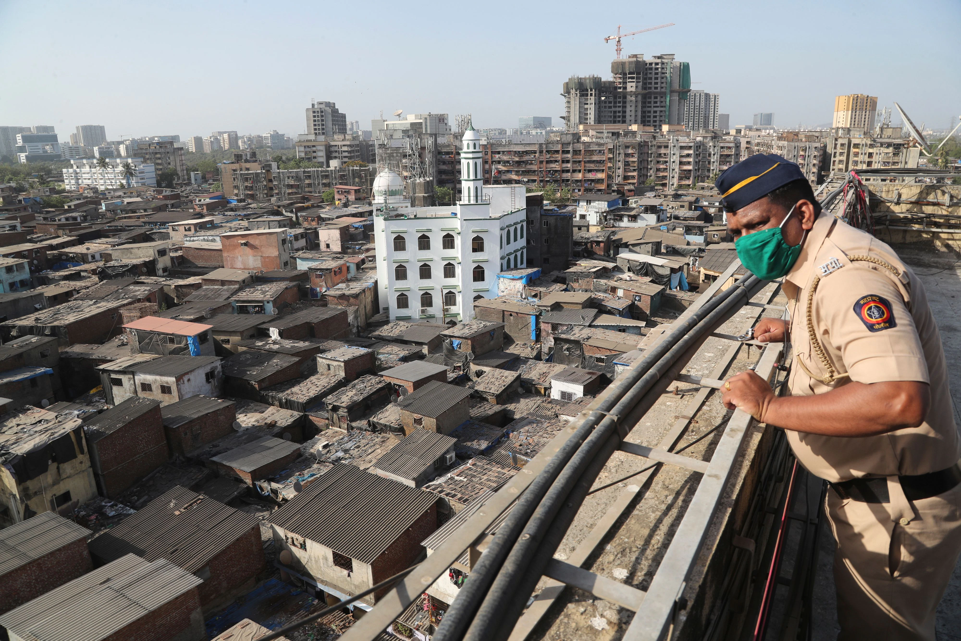 Ein indischer Polizist blickt auf das Slum-Viertel Dharavi in Mumbai. Symbolbild