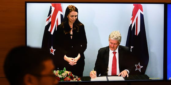Neuseelands Premierministerin Jacinda Ardern sieht ihrem Handelsminister bei der Unterzeichnung zu