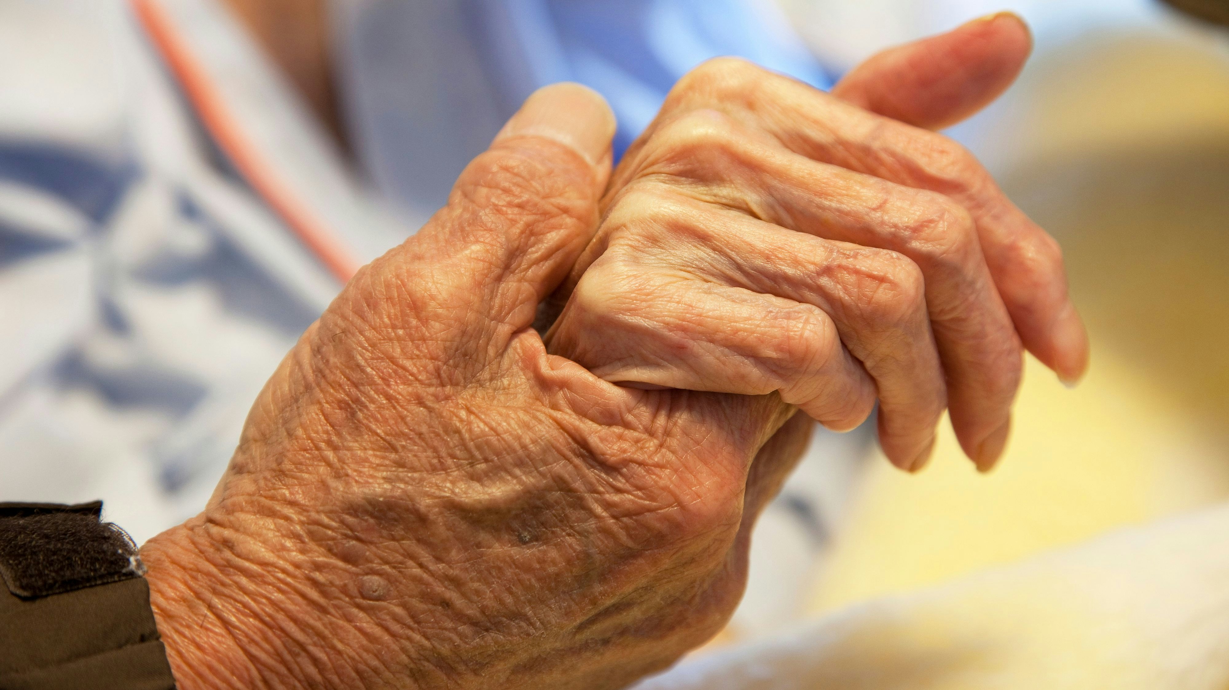 Ein älteres Ehepaar hält sich an den Händen. Symbolbild