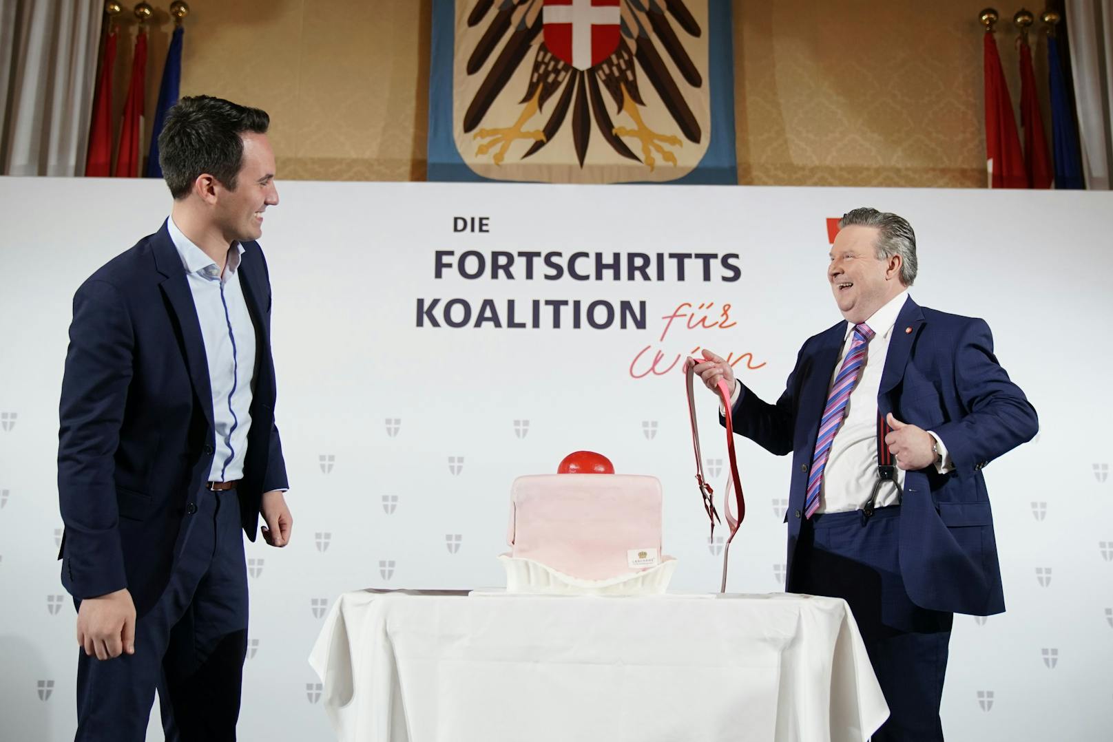 Bürgermeister Michael Ludwig (SPÖ) überraschte Bald-Vize-Bürgermeister Christoph Wiederkehr mit einem Riesen-Punschkrapfen. Der revanchierte sich mit rot-pinken Hosenträgern.