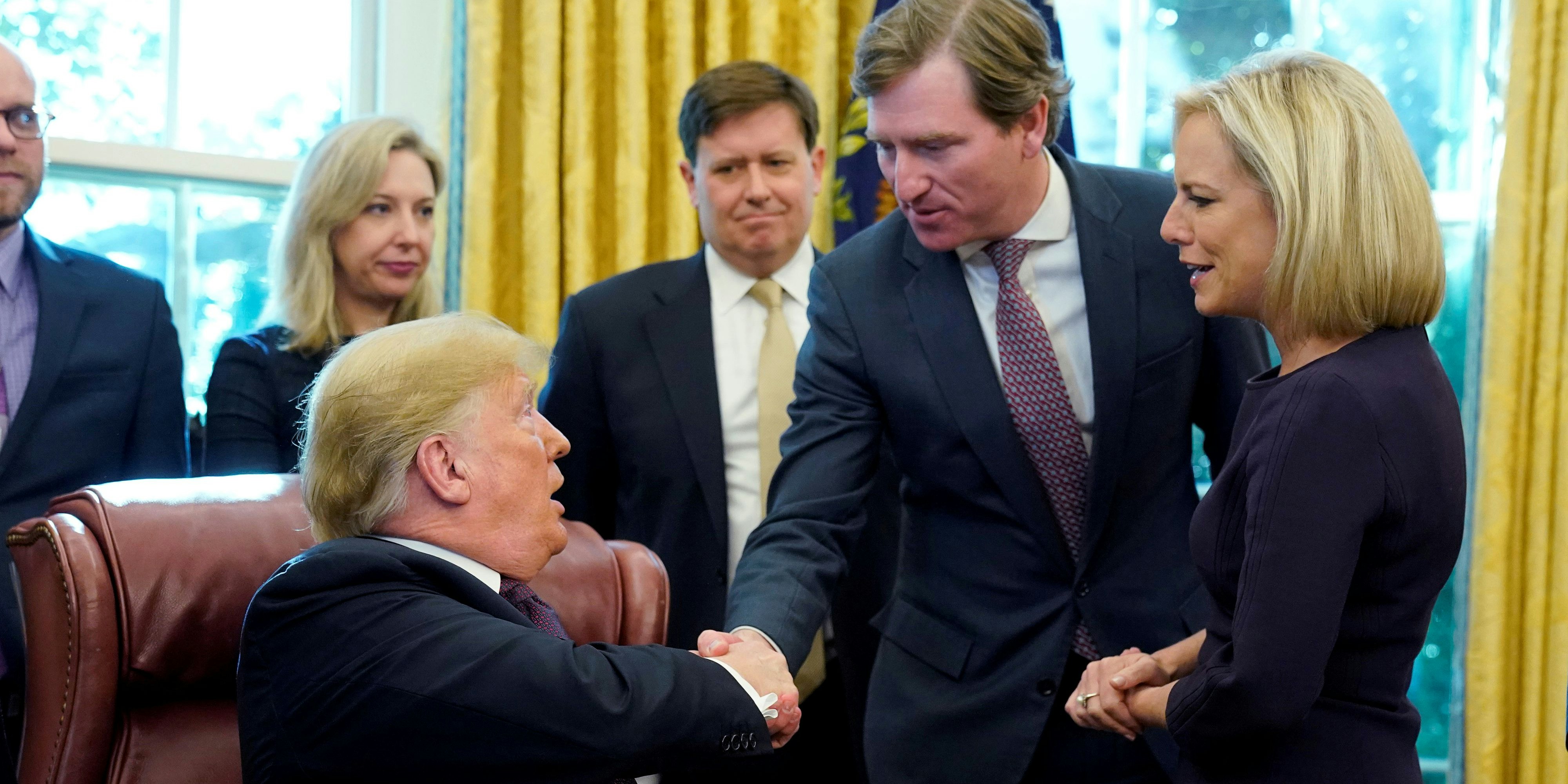 FILE PHOTO: U.S. President Donald Trump shakes hands with Chris Krebs, the director of the Cybersecurity and Infrastructure Security Agency (CISA) as DHS Secretary Kirstjen Nielsen (R) looks on after a signing ceremony for the Cybersecurity and Infrastructure Security Agency Act in the Oval Office of the White House in Washington, U.S. November 16, 2018. REUTERS/Jonathan Ernst/File Photo