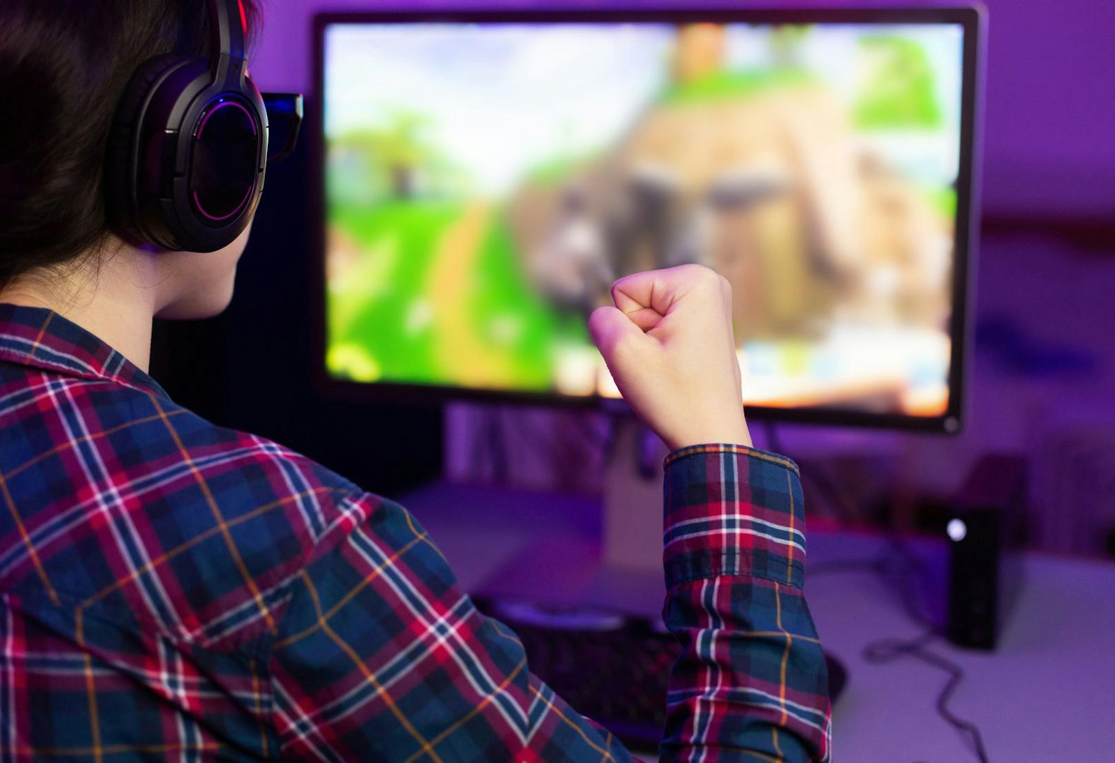 Female gamer winning in online video game and celebrating victory, wearing headphones