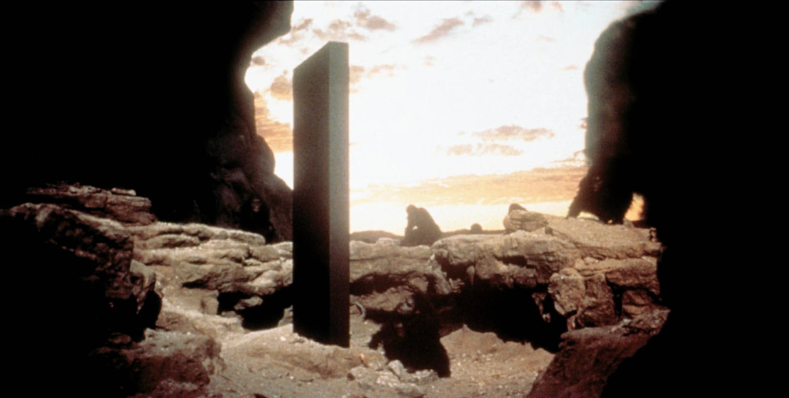 Szene aus "2001: A Space Odyssey": Steinzeitliche Affenmenschen untersuchen einen seltsamen Monolithen in der Wüste