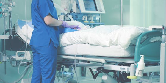 Eine Pflegerin kümmert sich um einen Patienten der Intensivstation. Symbolbild