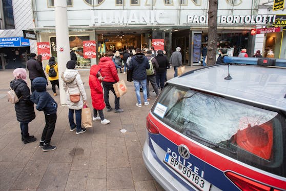 Polizeifahrzeug stehen vor der überfüllten Filiale einer Schuhmodenkette in der Mariahilfer Straße in Wien am 4. November 2020