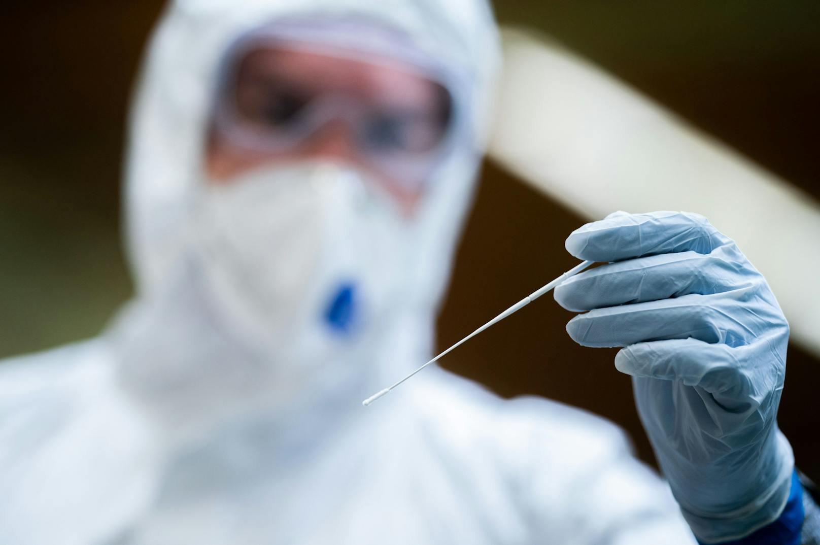 Ein Mediziner hält ein Teststäbchen für einen Antigen-Test.