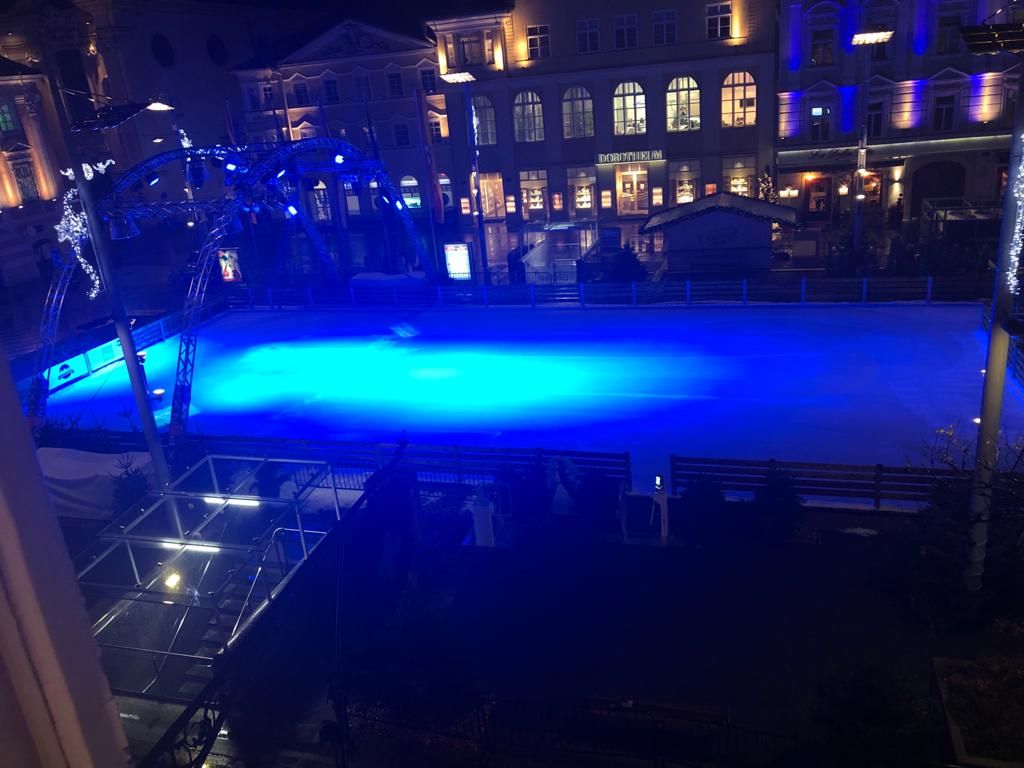 In einem mystischen blauen Licht erstrahlt der Eislaufplatz am Abend.