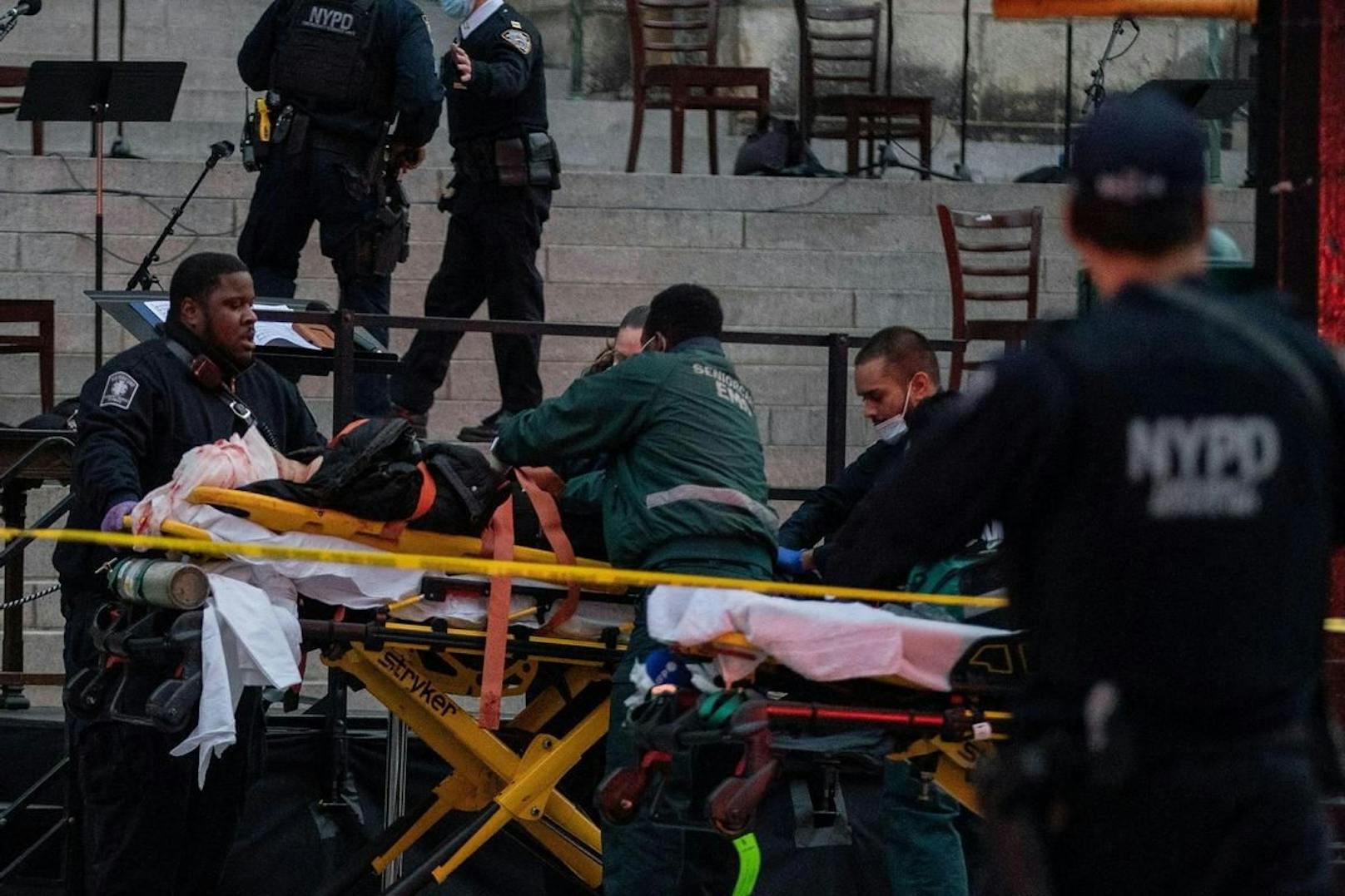 Von drei Polizisten niedergeschossen: Der Verdächtige wird von der Ambulanz zunächst weggebracht. (13. Dezember 2020)