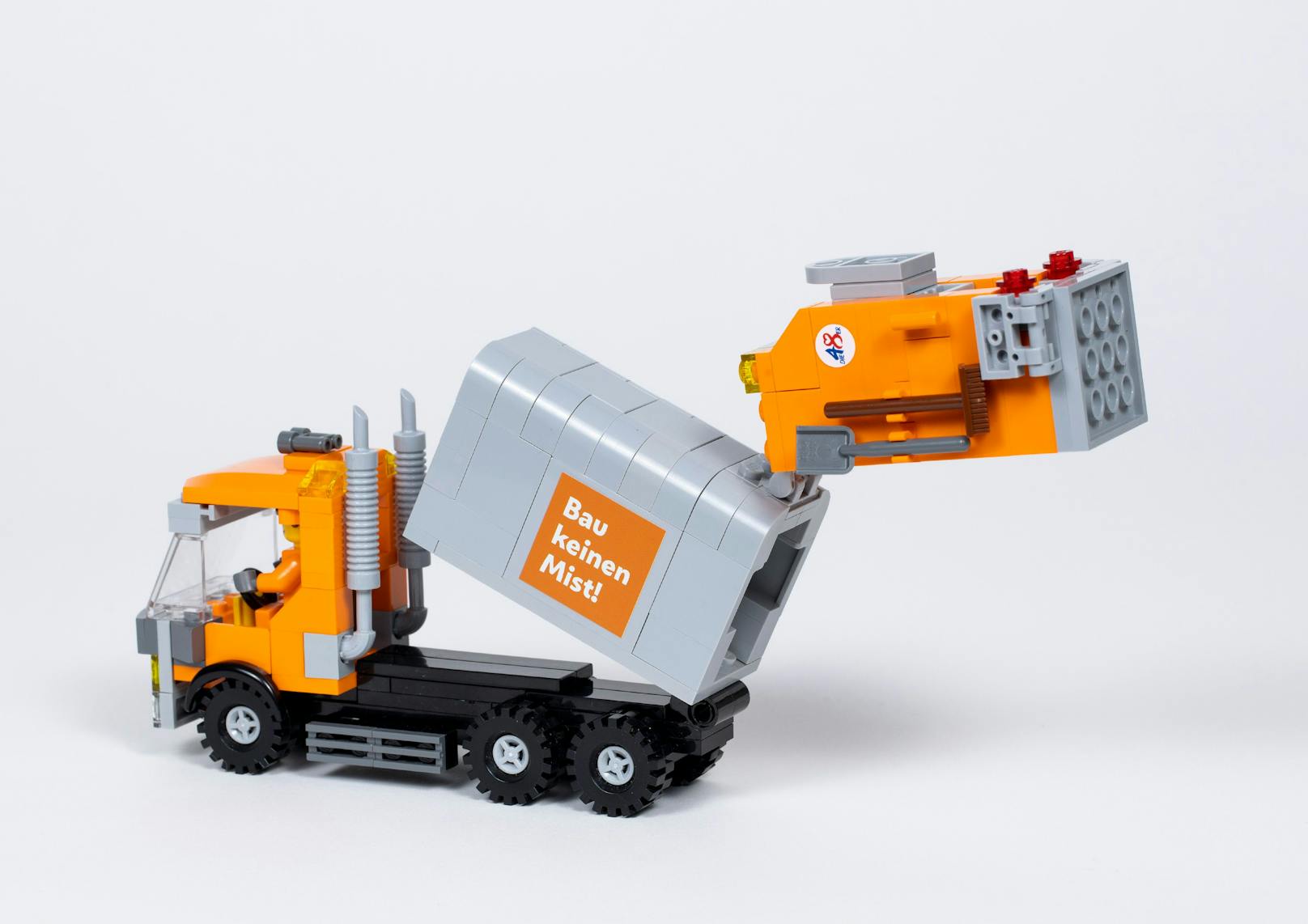 Das aus insgesamt 263 Einzelteilen bestehende Set enthält ein Müllsammelfahrzeug mit beweglichen Teilen, zwei orangene Figuren, sechs Behälter mit verschiedenen Aufklebern sowie eine Bauanleitung.