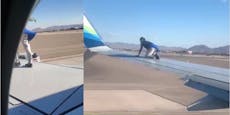 Mann klettert kurz vor Start auf Flugzeug-Flügel