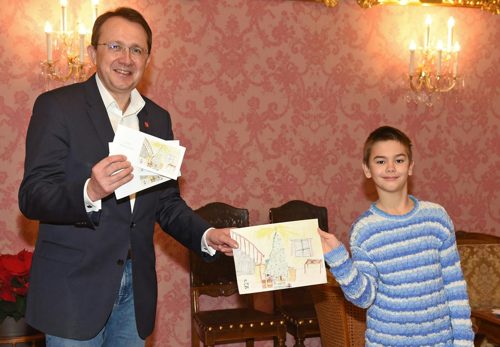 Bürgermeister Matthias Stadler und Niklas Zauner, Schüler der Volksschule Stattersdorf, mit der diesjährigen Weihnachtskarte.