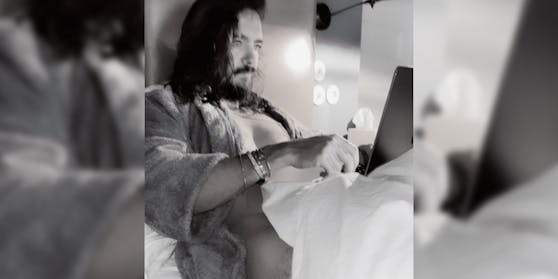 Tom Kaulitz, nur mit einer Decke bekleidet im Home Office.