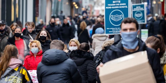 Menschen tragen im Freien eine Maske.