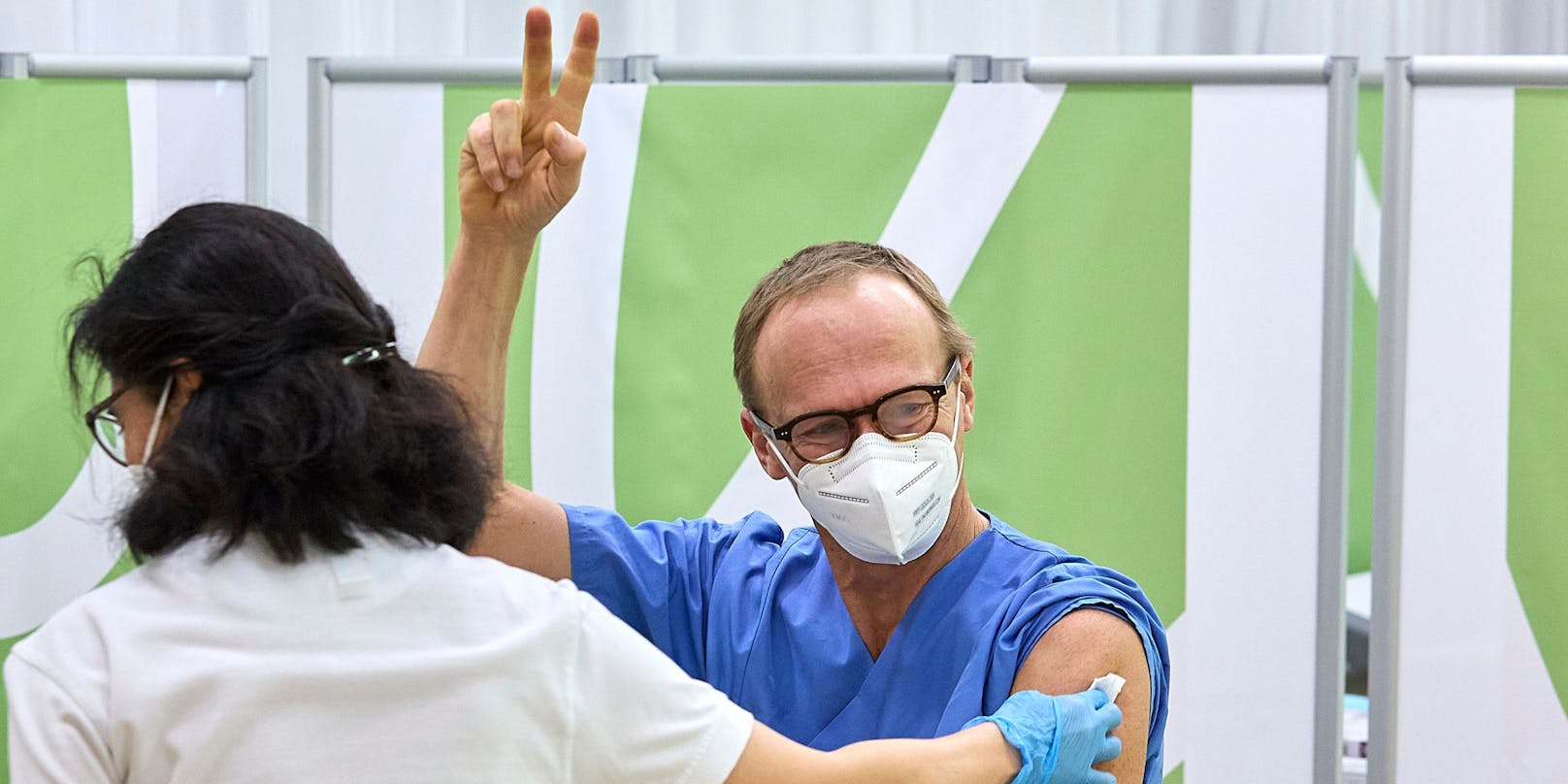Christoph Wenisch, der Leiter der Infektionsabteilung hat als Erster seine erste Impfung erhalten und streckt die Finger aus zum Victory-Zeichen nach erfolgter Impfung