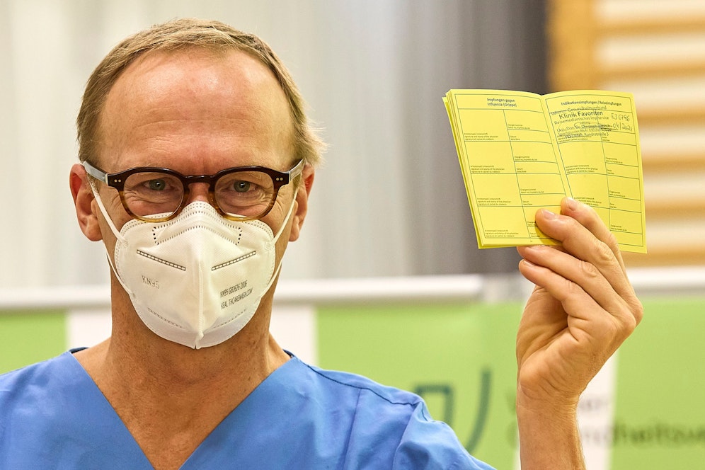 Christoph Wenisch zeigt nach der Impfung seinen aktualisierten Impfpass. 