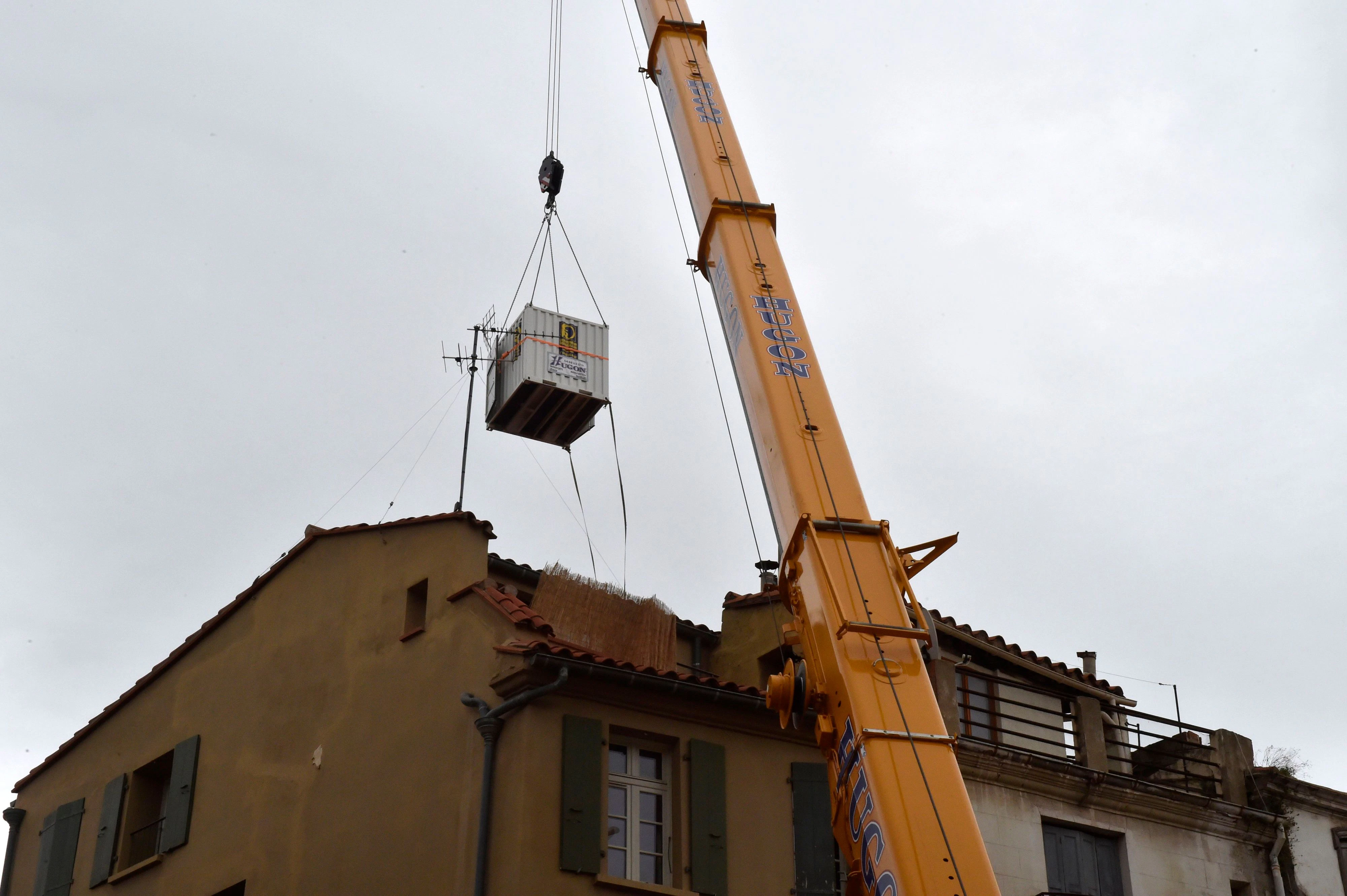 Download von www.picturedesk.com am 03.12.2020 (11:16).  A container is lifted over a building by a crane before being used by doctors of the SAMU (French Urgent Medical Aid Service) to evacuate a man suffering from morbid obesity from the first floor of his home in Perpignan, southwestern France, on December 1, 2020. (Photo by RAYMOND ROIG / AFP) - 20201201_PD1966 - Rechteinfo: Rights Managed (RM) Nur für redaktionelle Nutzung! Werbliche Nutzung erfordert Freigabe: bitte schicken Sie uns eine Anfrage.