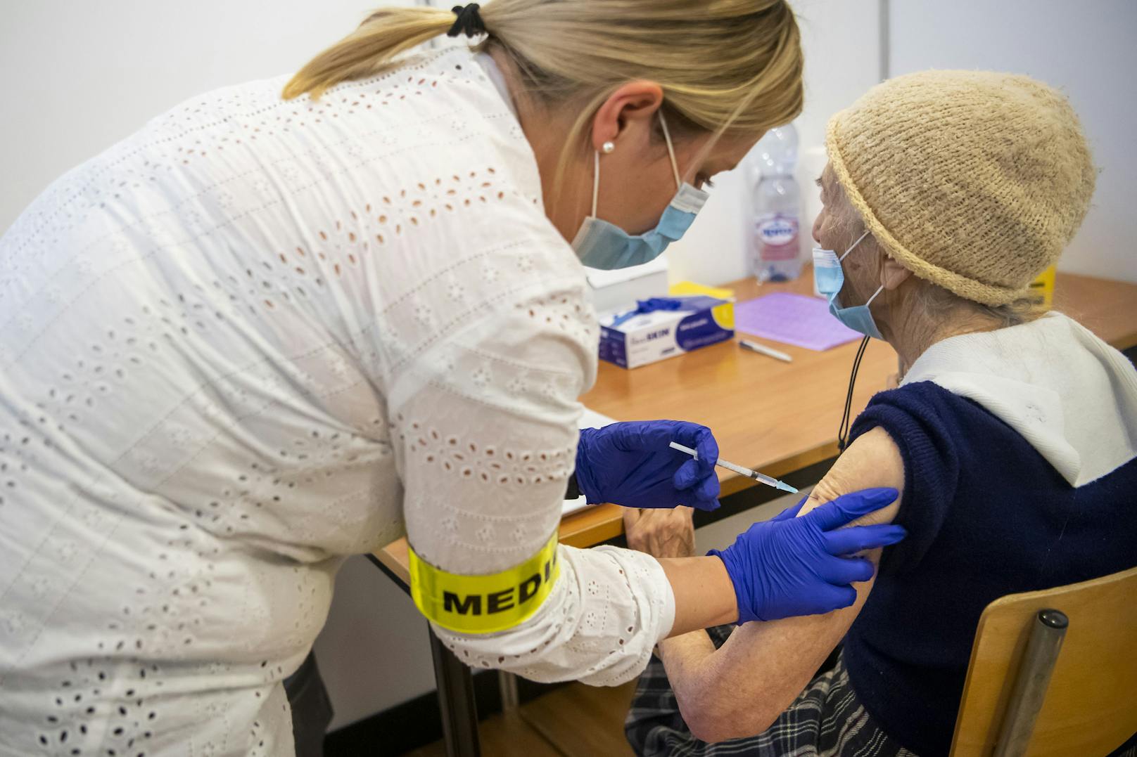 Eine Krankenschwester gibt einem älteren Patienten in Neuenburg die erste Dosis des Pfizer-BioNTech-Impfstoffs.