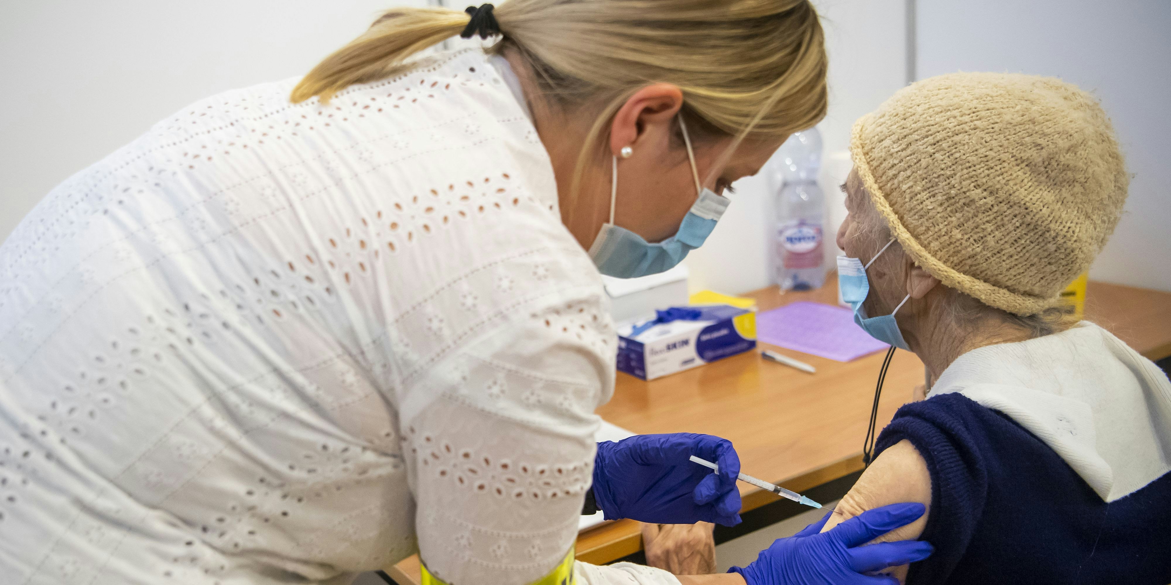 Eine Krankenschwester gibt einem älteren Patienten aus Neuenburg die erste Dosis des Pfizer-BioNTech-Impfstoffs anlässlich des Starts der Impfung gegen Sars-Cov-2 im Kanton Neuenburg während der Coronavirus-Krise (Covid-19) am Montag 28. Dezember 2020 in Mycorama in Cernier. (KEYSTONE / Jean-Christophe Bott)