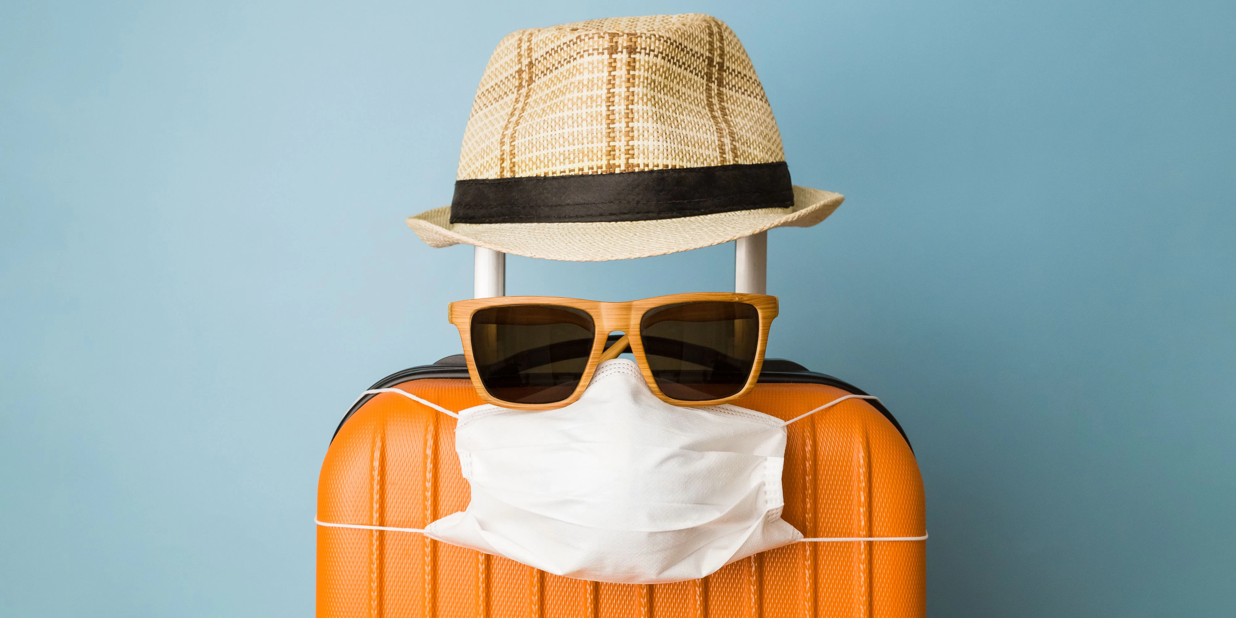 Travel restriction abstract made of tourist in form of of luggage with face mask, sunglasses and hat.