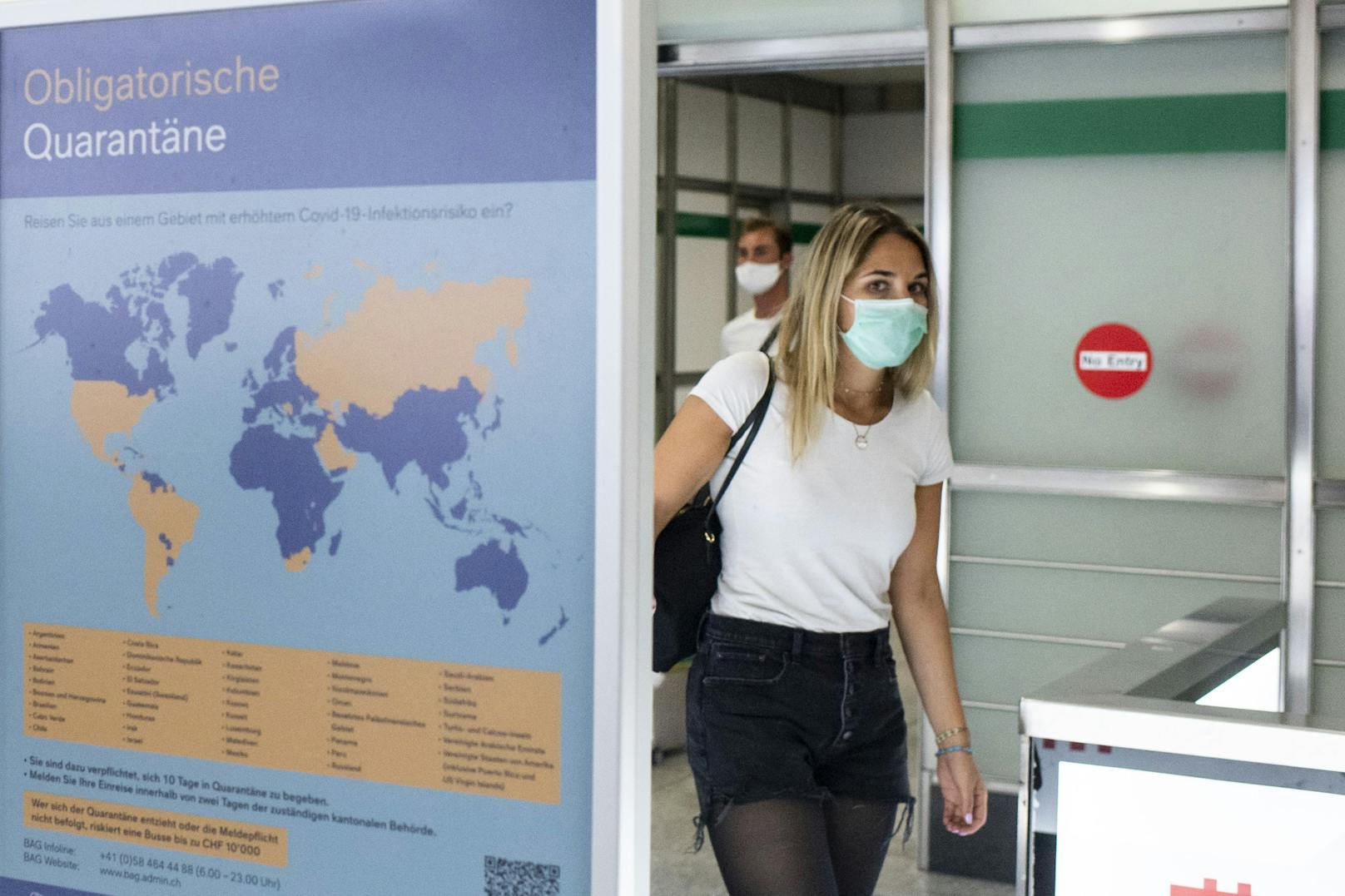 Ein Plakat weist bei der Ankunft am Flughafen Zürich auf die obligatorische Quarantäne bei der Einreise aus bestimmten Ländern hin. Archivbild, August 2020