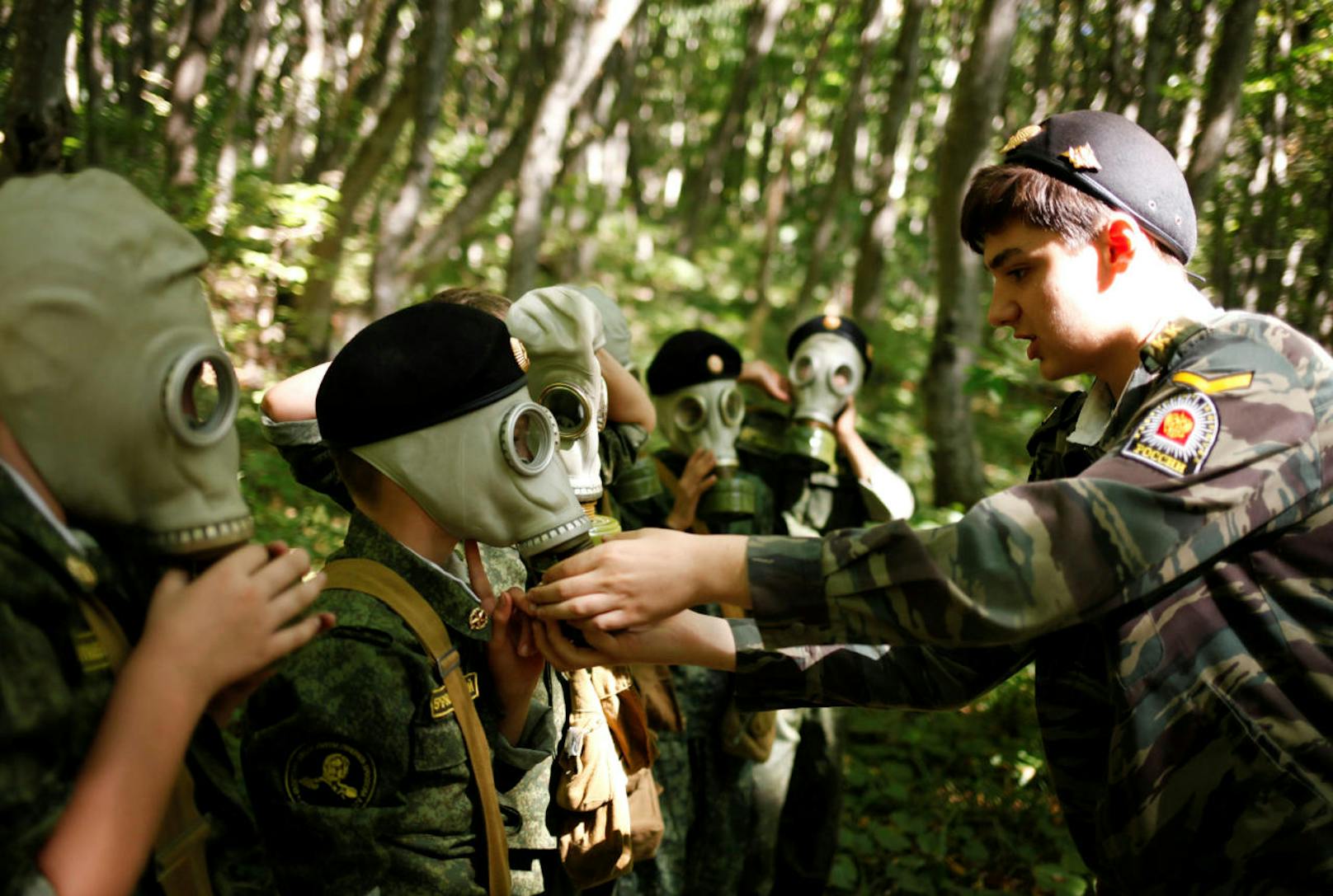 Fünftklässler lernen, wie man eine Gasmaske richtig trägt.