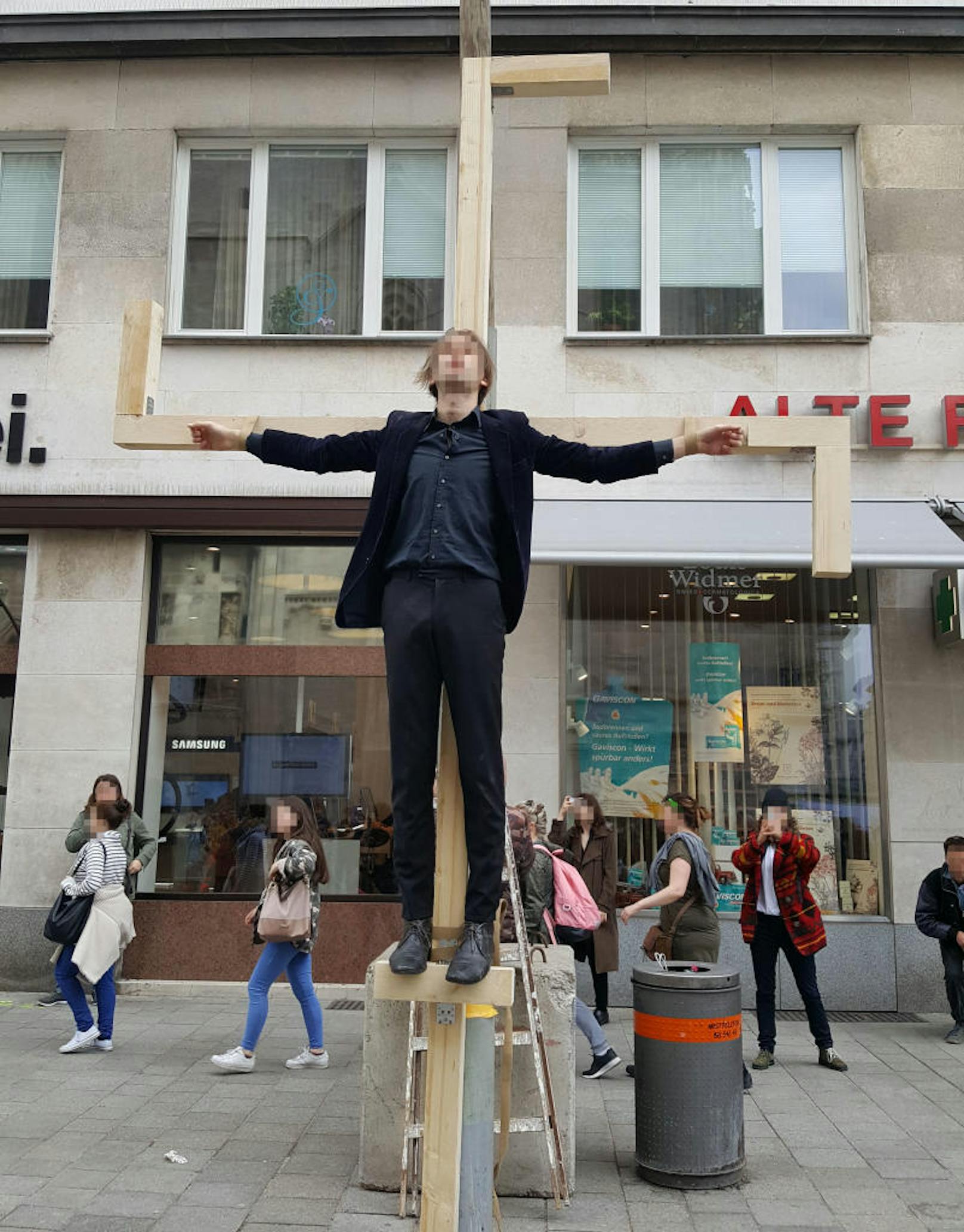 Ein Aktivist hing in Jesus-Pose an einem überdimensionalen Hakenkreuz am Stephansplatz