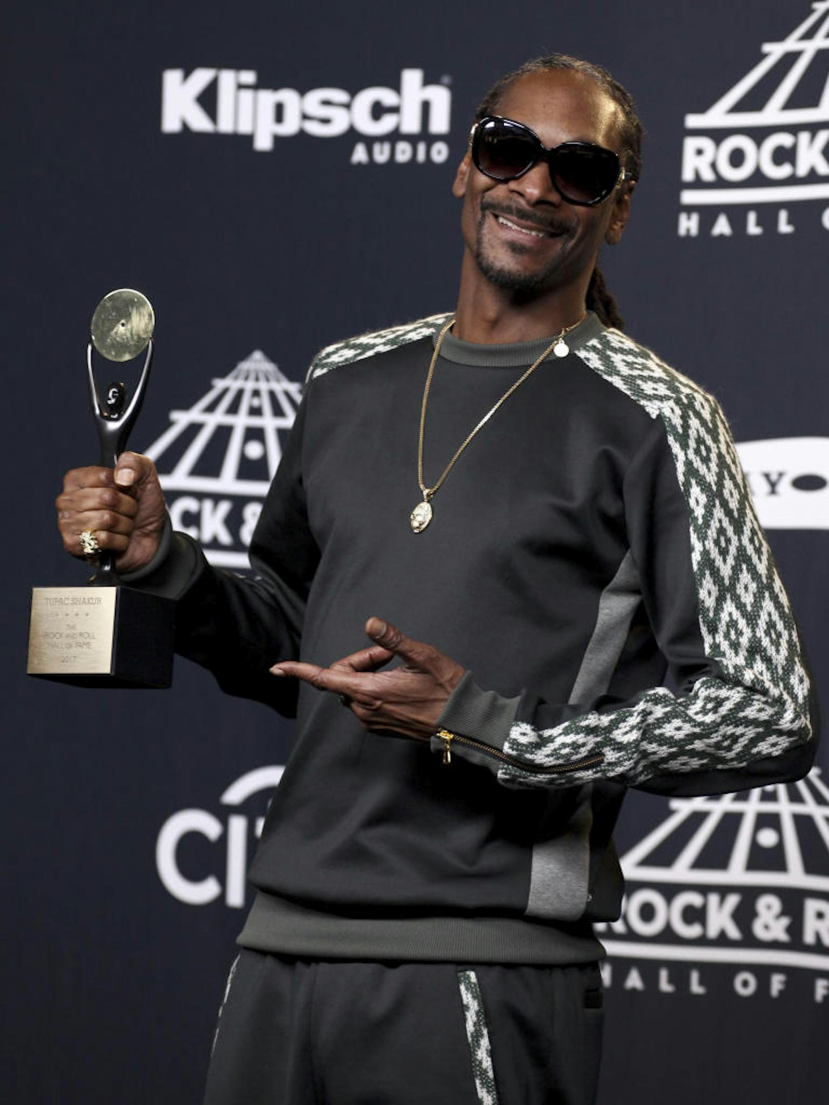 Snoop Dogg poses with an award given posthumously to Tupac Shakur in the 2017 Rock and Roll Hall of Fame induction ceremony press room at the Barclays Center on Friday, April 7, 2017, in New York. (Photo by Andy Kropa/Invision/AP)