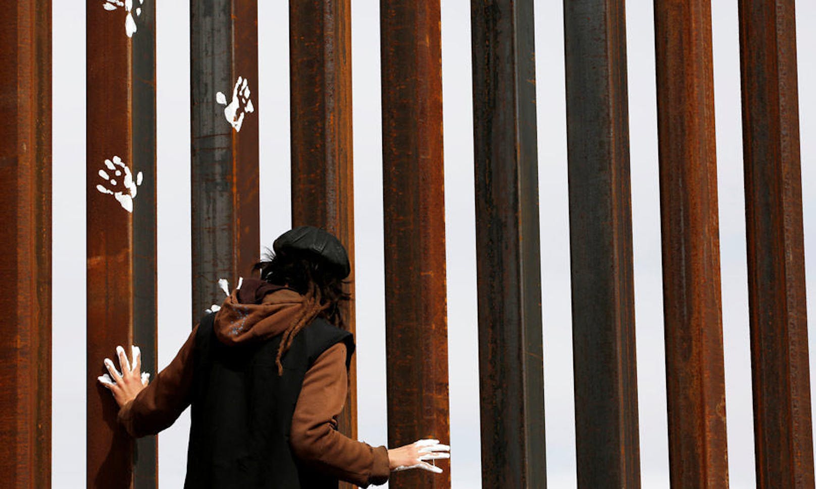 26.02.2017: Die Grenze zwischen den USA und Mexiko ist derzeit in aller Munde. Ein Aktivist bringt mit weißen Handabdrücken am Grenzzaun seinen Protest an Trumps Einwanderunsgpolitik zum Ausdruck.