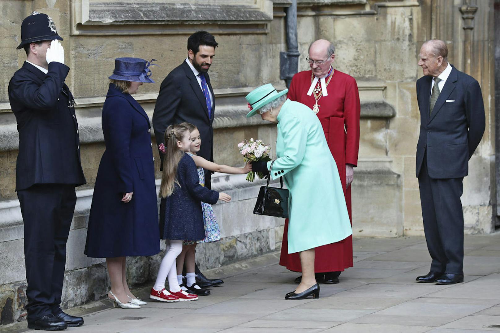 Die Queen erhält von zwei Mädchen einen Blumenstrauß.