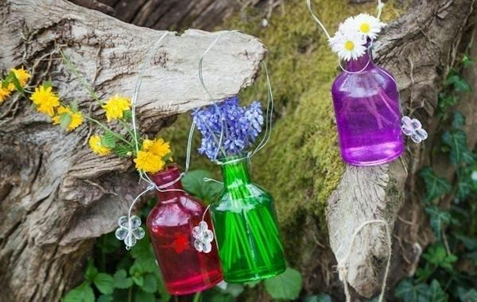Flaschen-Wanne: Frische, bunte Blumen sind bei jedem Gartenfest ein Hingucker. Nehmen Sie dafür schlichte Glasflaschen zu Hand und befüllen Sie sie mit Wasser. Nun geben Sie frische Blumen in die DIY-Vasen, binden ein passende Band um den Flaschen-Hals und befestigen Sie die Dekoration an Bäumen, am Balkongeländer oder in den Speichen des Sonnenschirms.